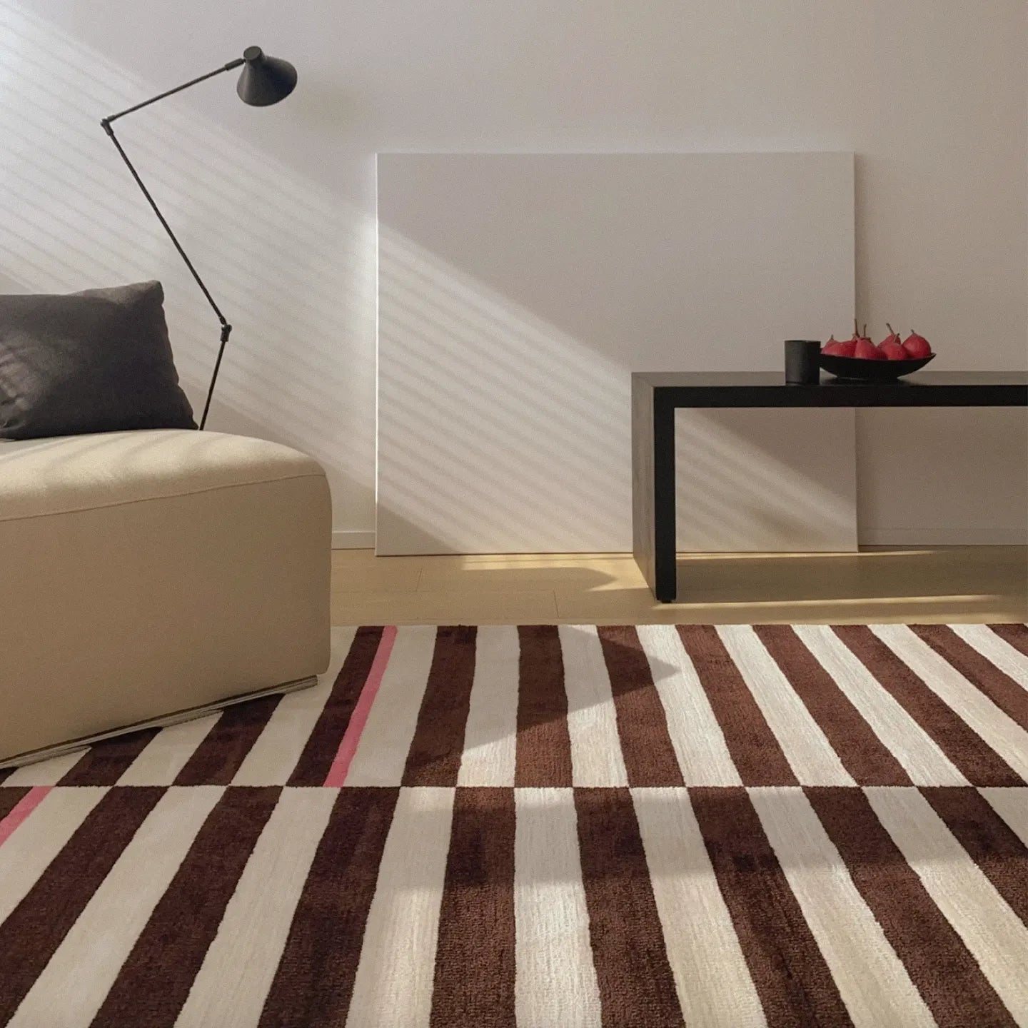 Modern living room with a sofa, a decorative item, and Clara White and Chocolate Brown Modern Offset Stripe Rug by Housenfriends