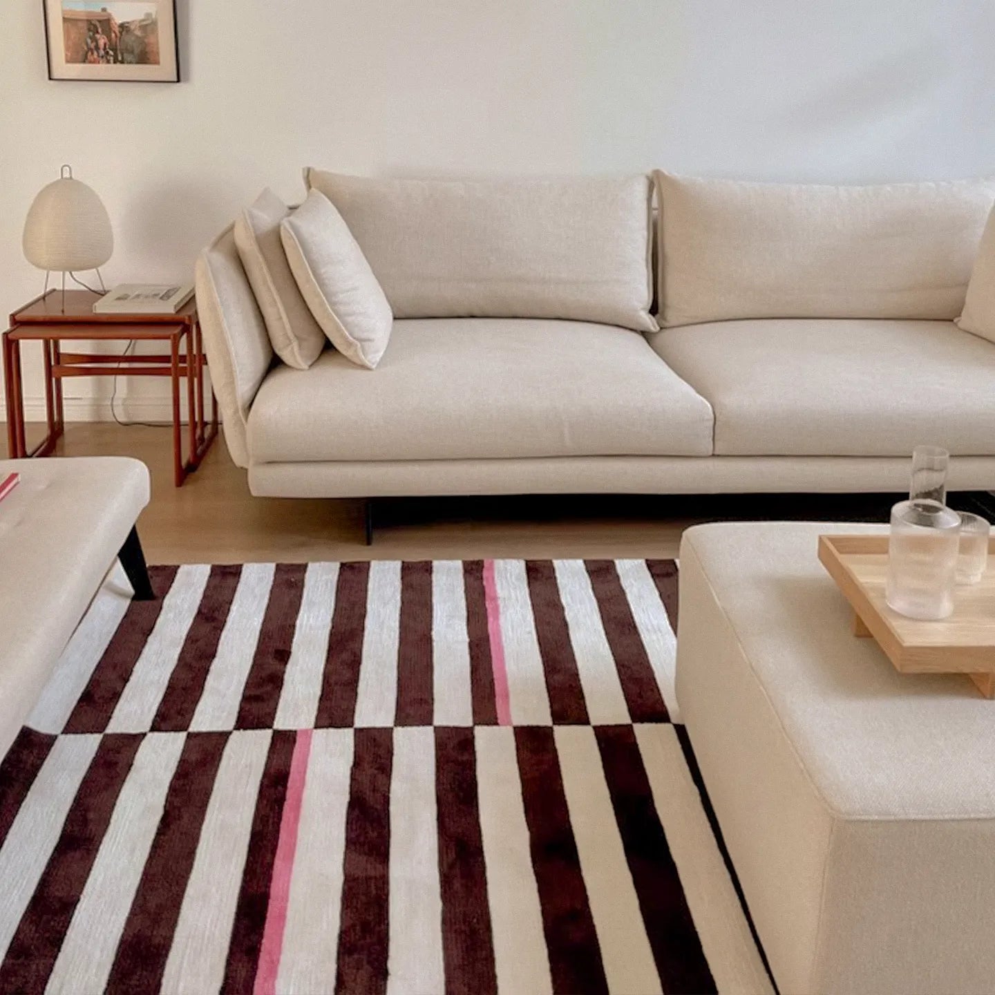 Beige sectional sofa in a living room with Clara White and Chocolate Brown Modern Offset Stripe Rug by Housenfriends