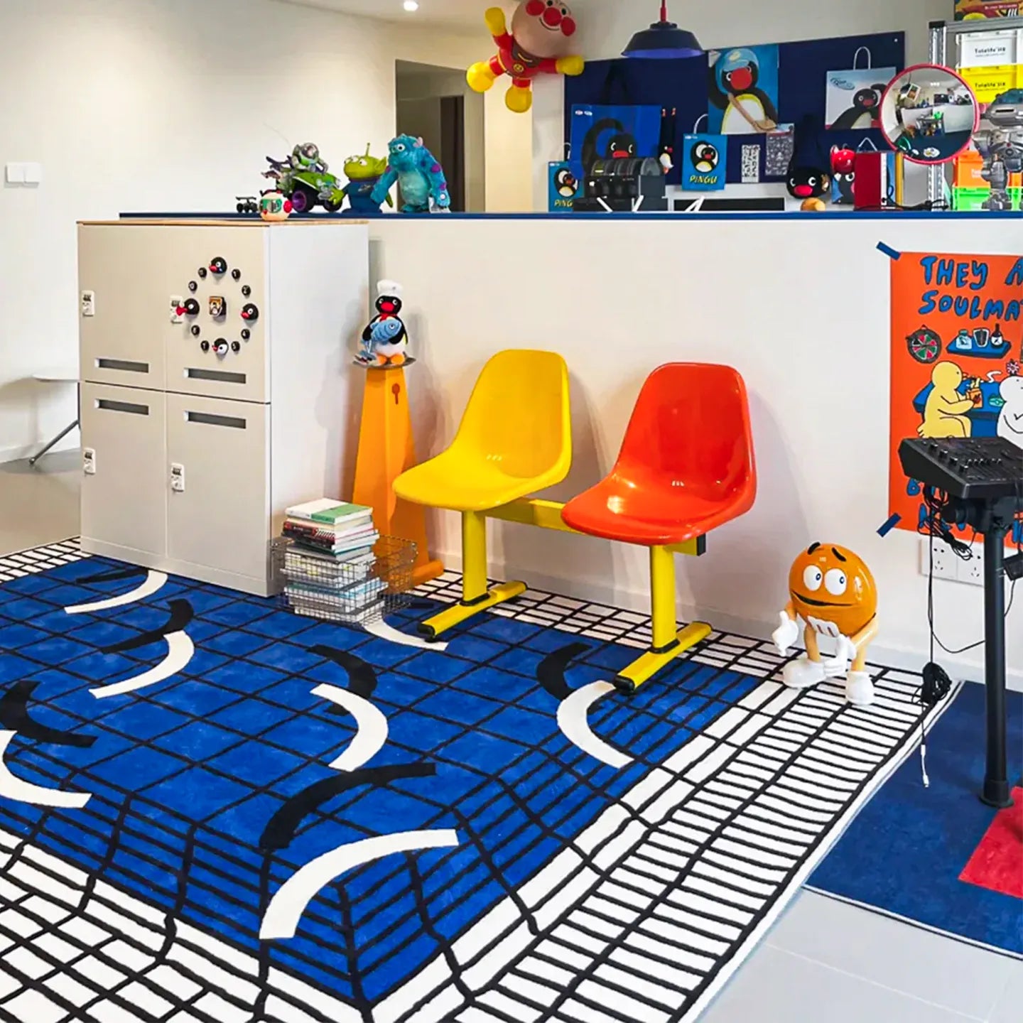 Living room with colourful chairs, toys, and the Poolside blue and white grid modern graphic rug by Housenfriends