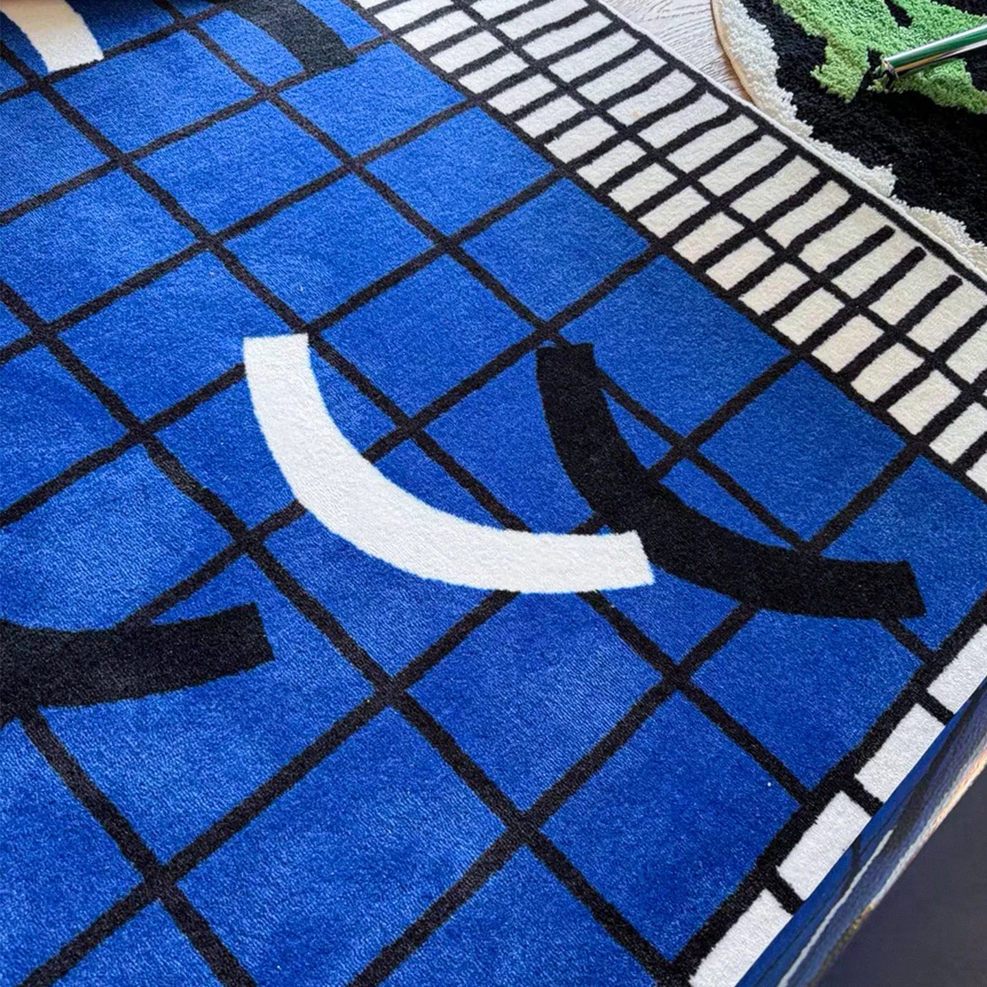 Close-up of Poolside abstract checkered rug in blue, white, and black by Housenfriends, showing texture