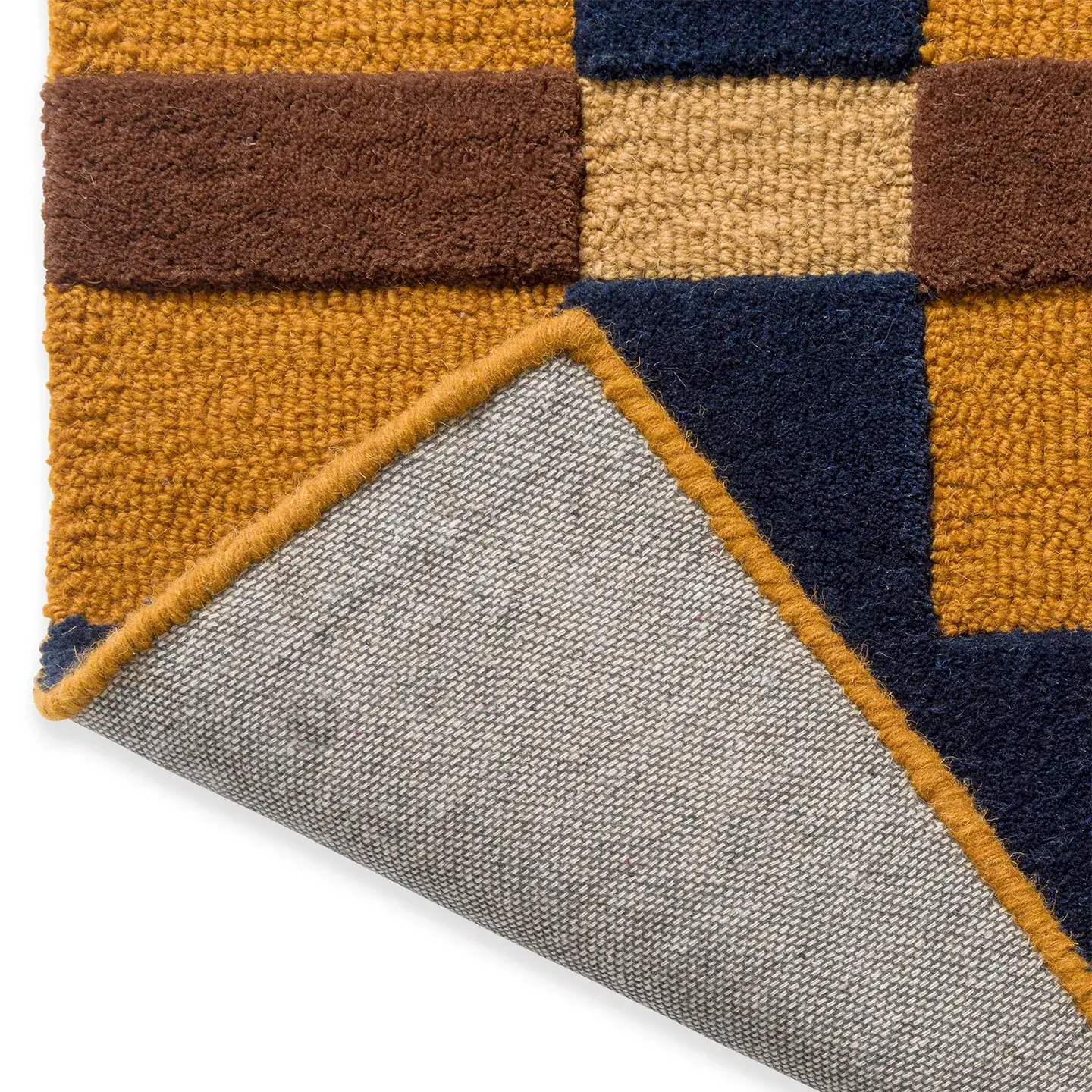 Close-up of the backing of the Juno mustard, gold, and navy checkered tufted rug by Housenfriends