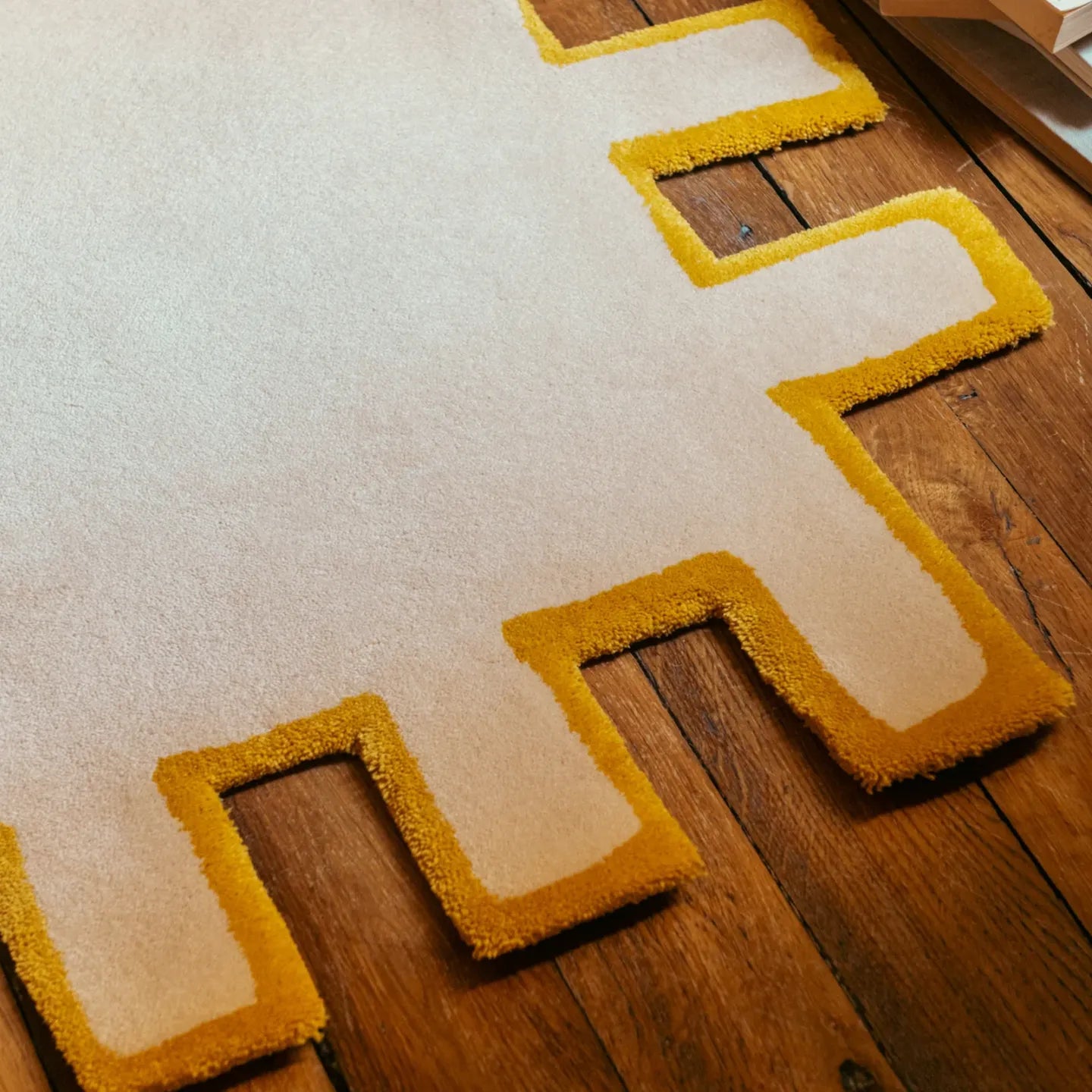 Corner of Biscuit beige shaggy abstract geometric rug with yellow border by Housenfriends on wooden floor