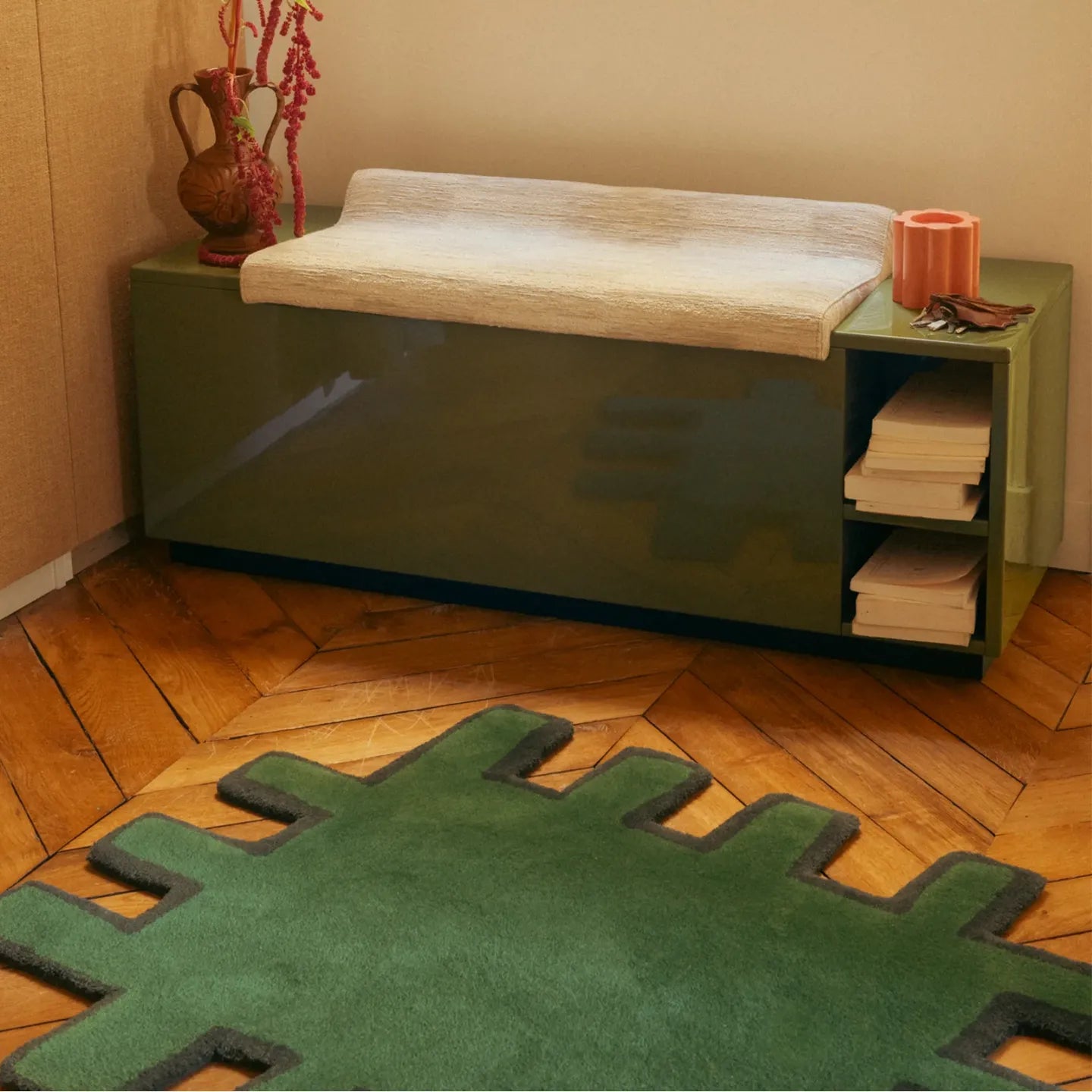 Biscuit Green shaggy abstract geometric rug with black border by Housenfriends on wooden floor under green bench.