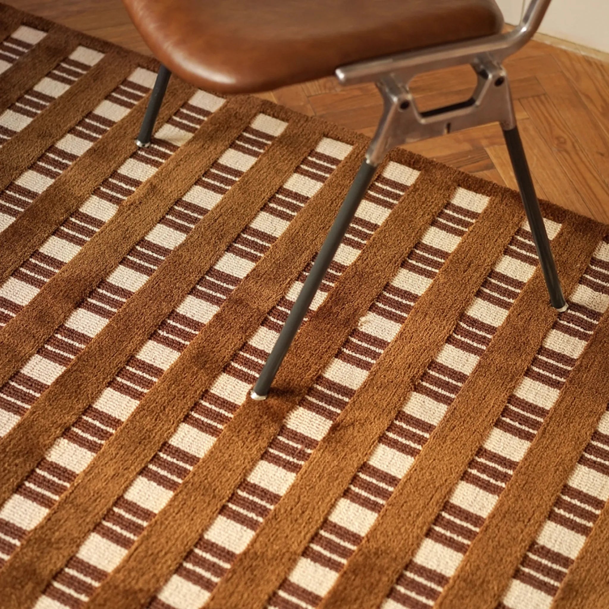 Amber Brown and Cream Checkered Textured Modern Rug with a chair on it