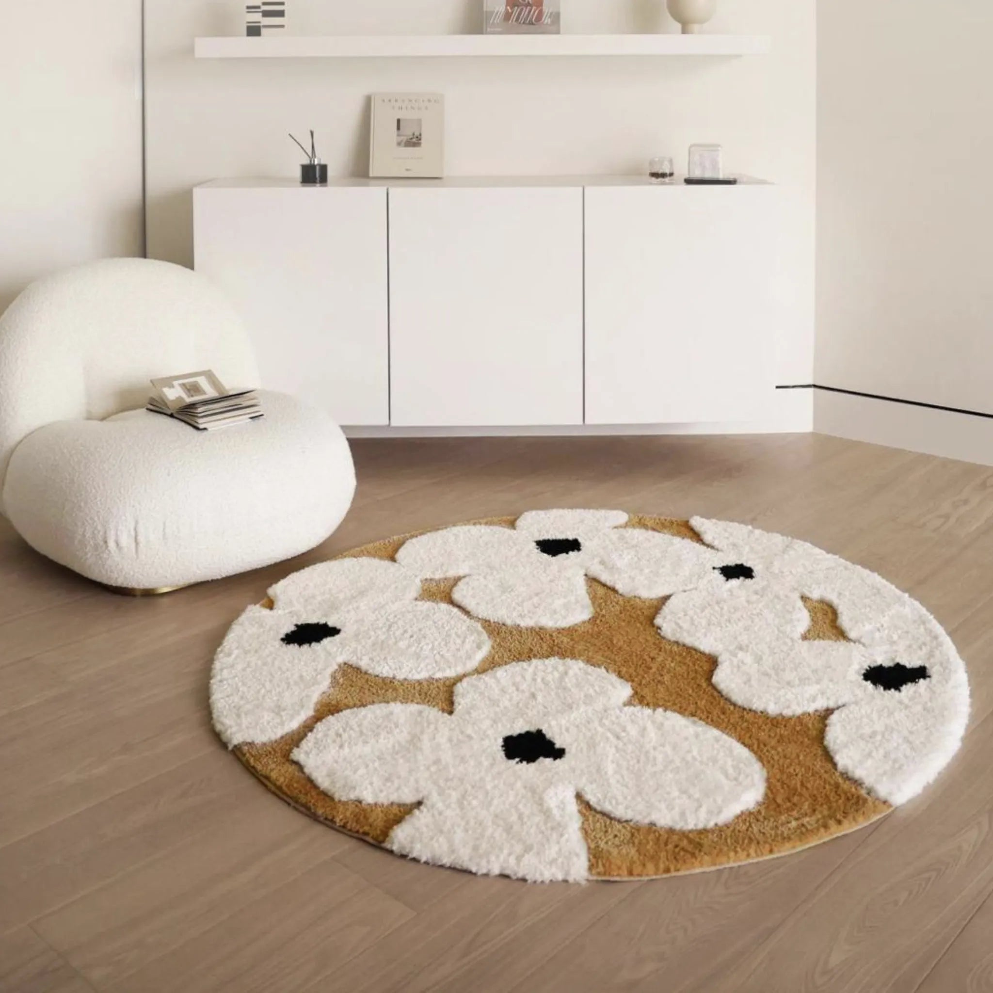 Brown Ivory Floral Round Rug by Housenfriends on a wooden floor with a white chair and cabinet.