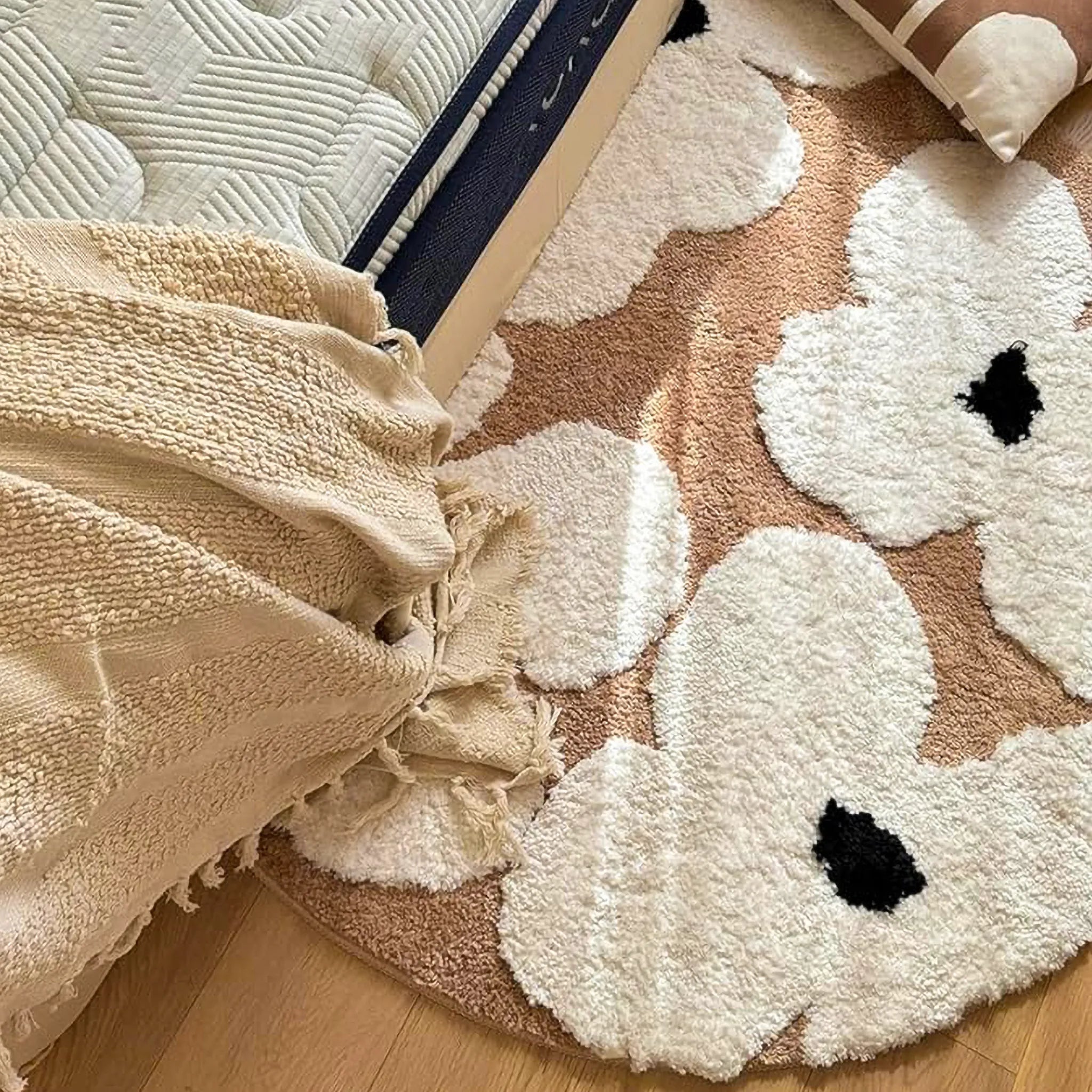 Liora Brown Ivory Floral Round Tufted High Low Rug by Housenfriends on a wooden floor, next to a beige towel.