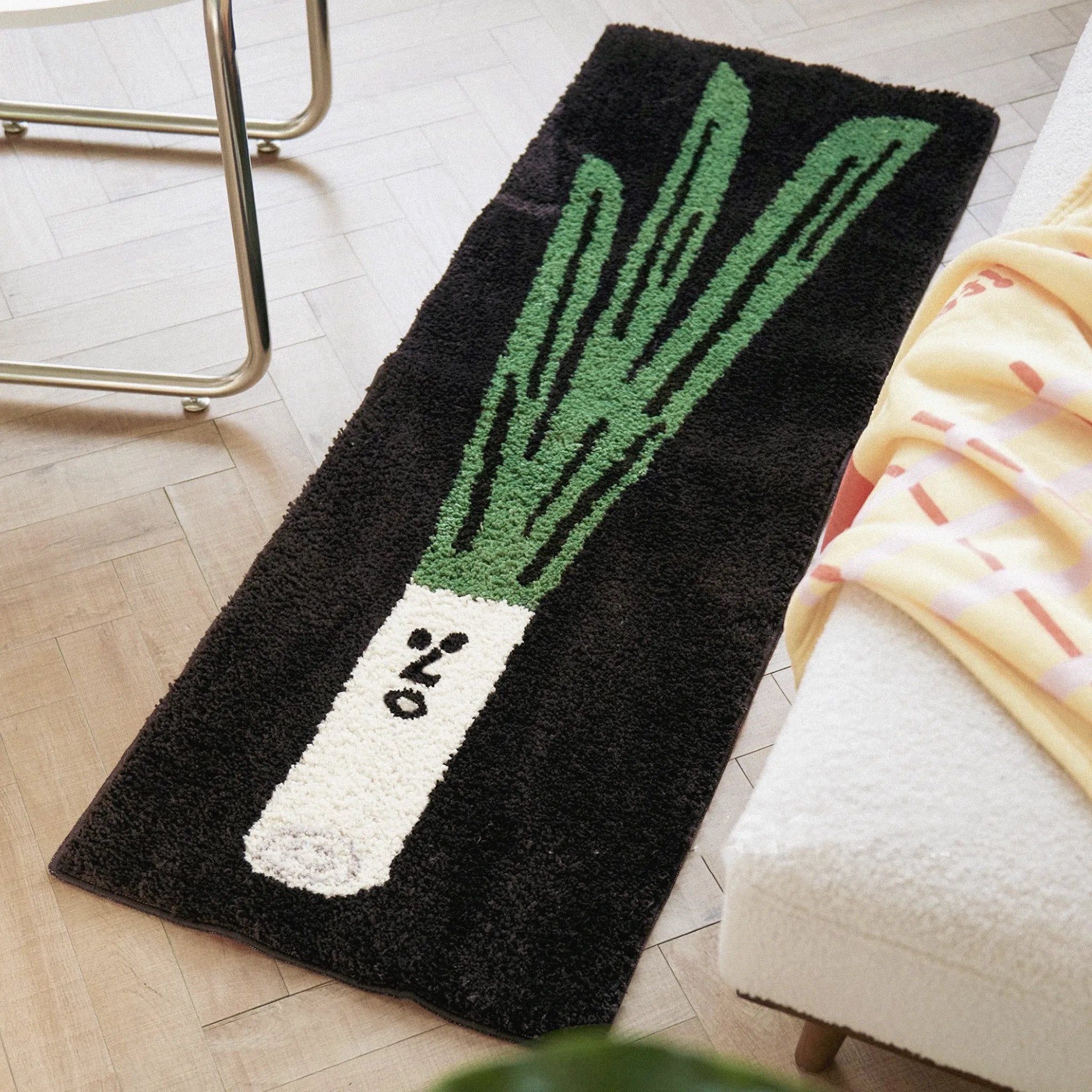 Green Onion Playful Black Runner Rug by Housenfriends on a wooden floor