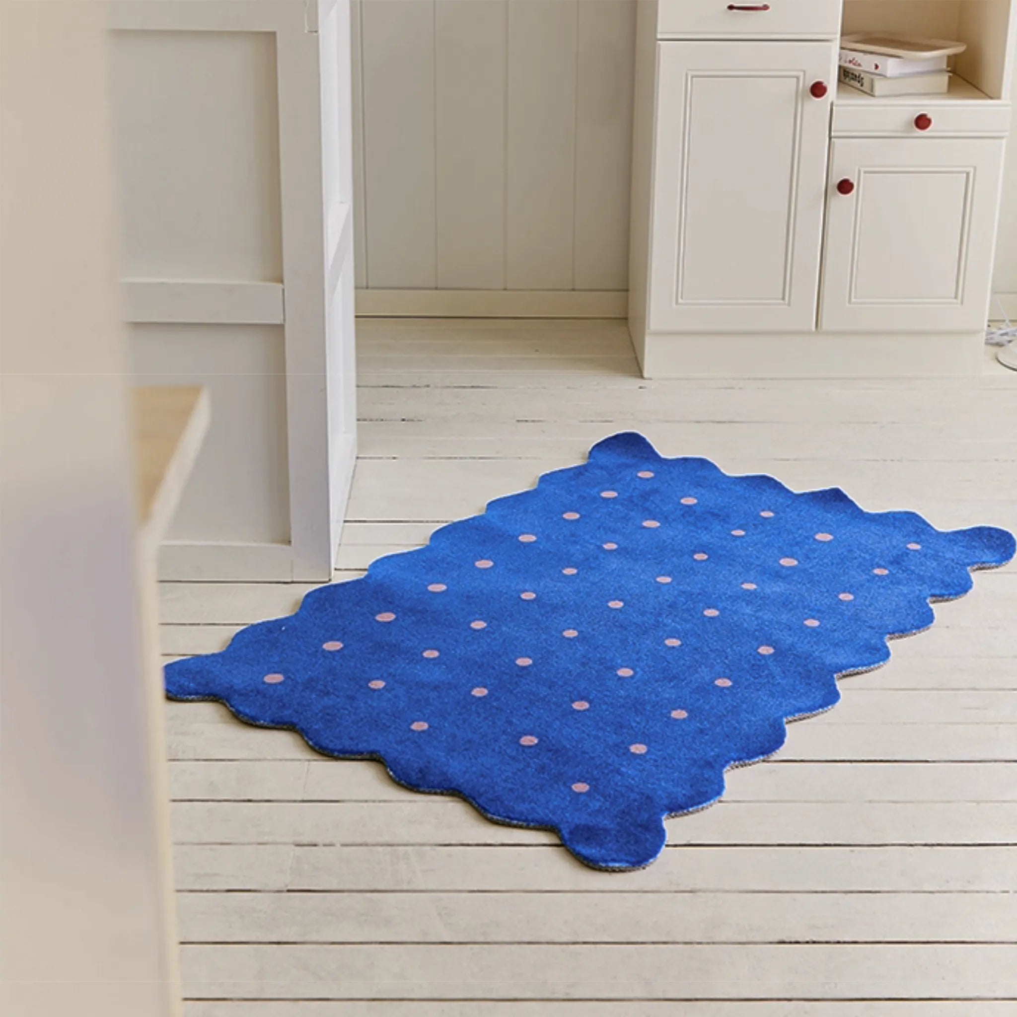 Arden Klein Blue & Pink Polka Dots Scalloped Rug by Housenfriends on a light wooden floor.