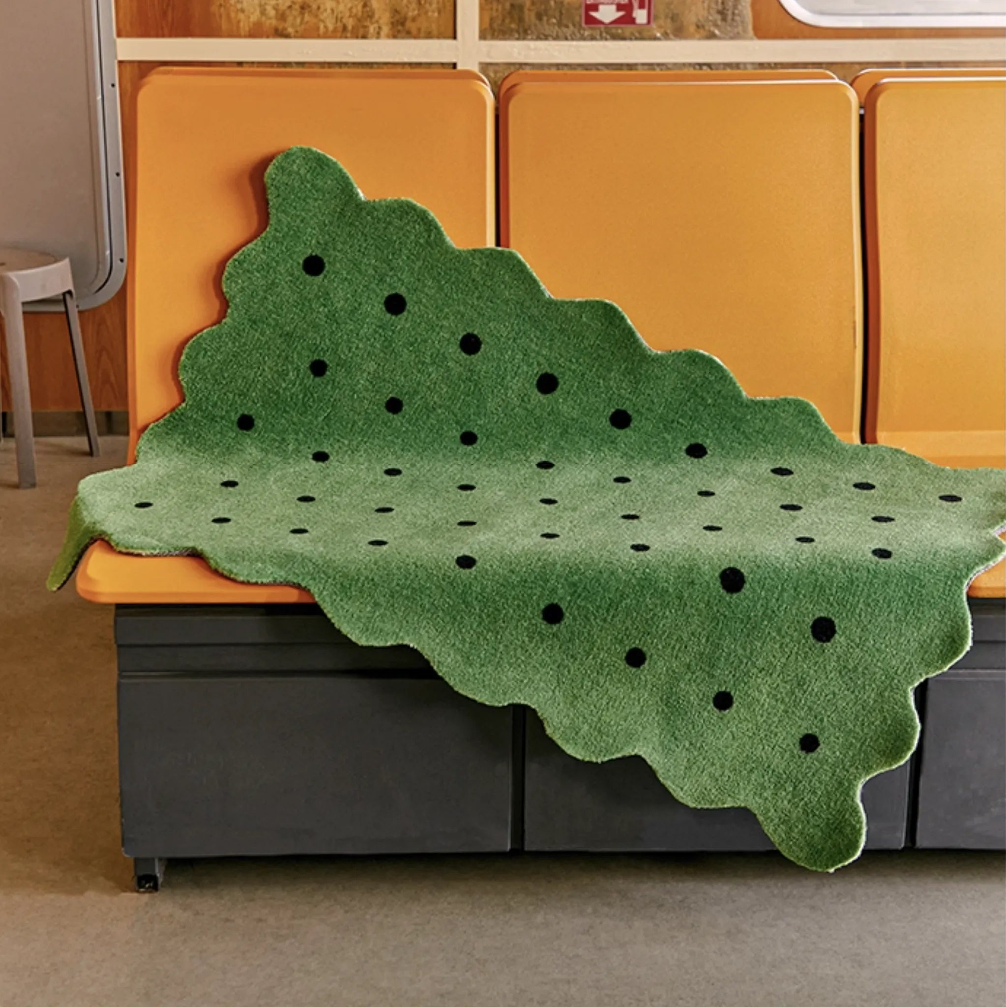 Arden Green & Black Polka Dots Scalloped Rug by Housenfriends on a yellow seat