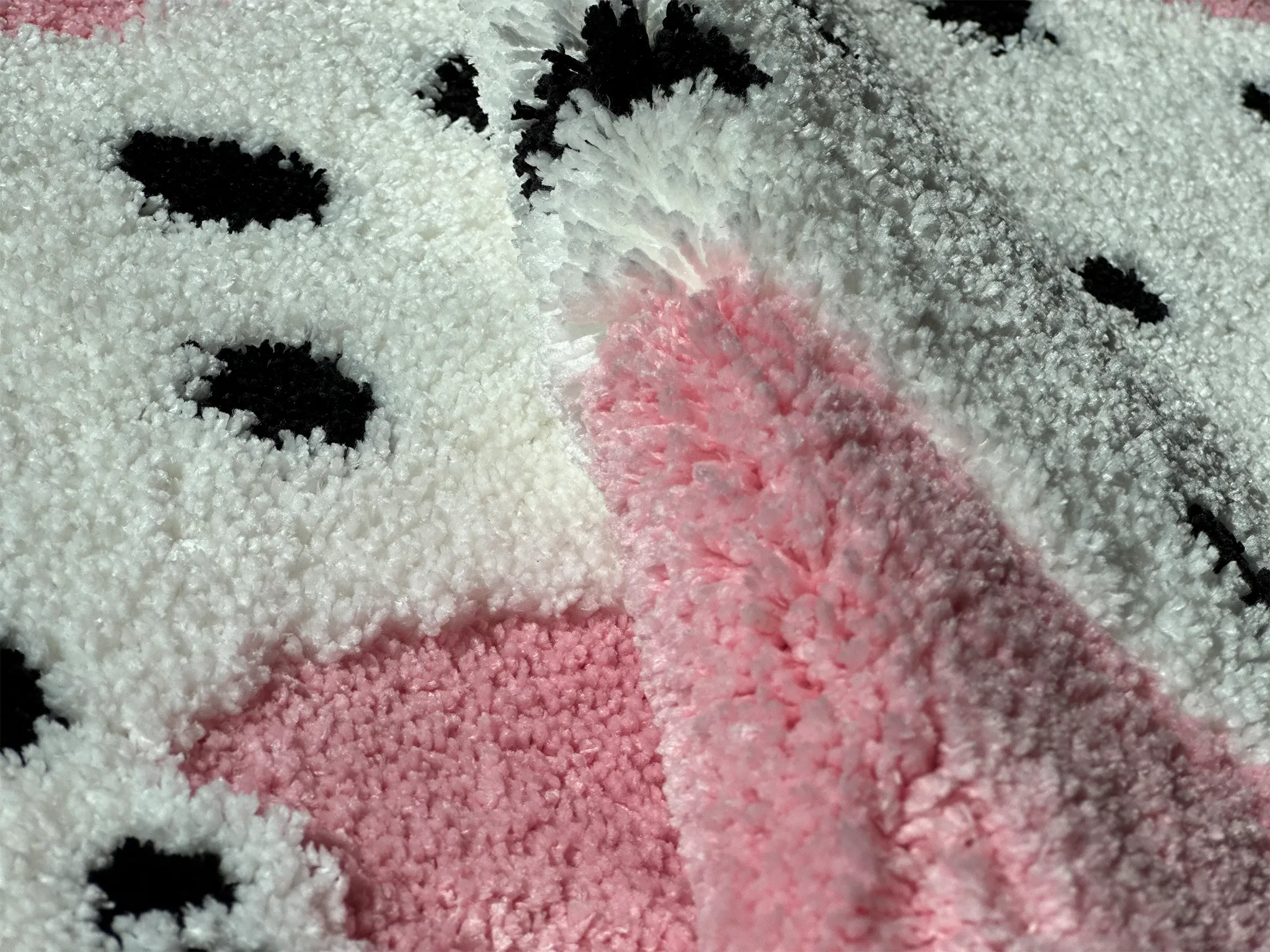Close-up of a pink and white texture of Blossom Pink Base White Leopard Shaped Tufted Rug