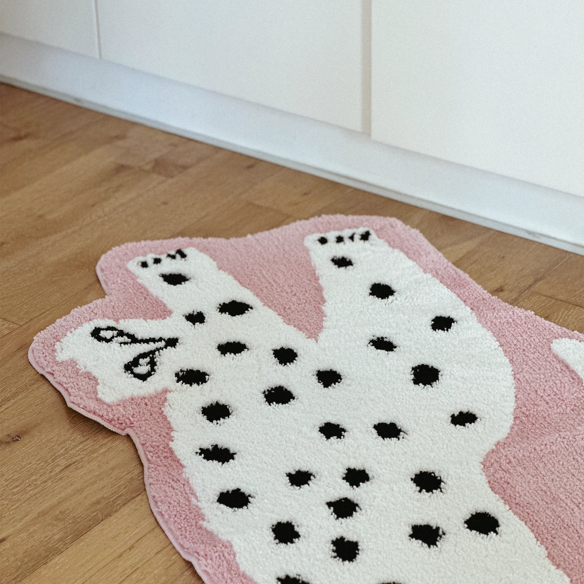 Layla Blossom Pink Base White Leopard Shaped Tufted Rug by Housenfriends on a wooden floor