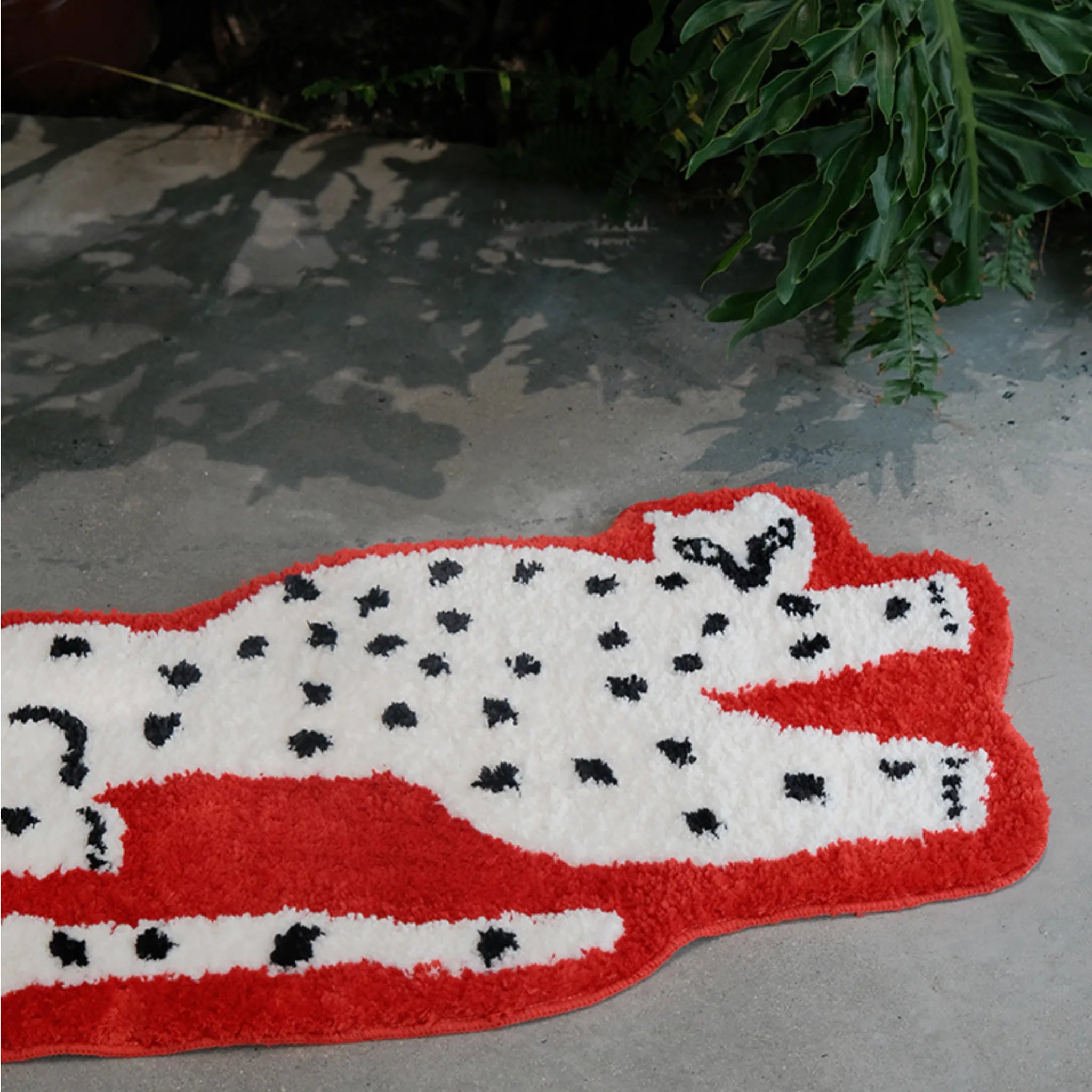 Layla Red Base White Leopard Shaped Tufted Rug by Housenfriends on a concrete floor
