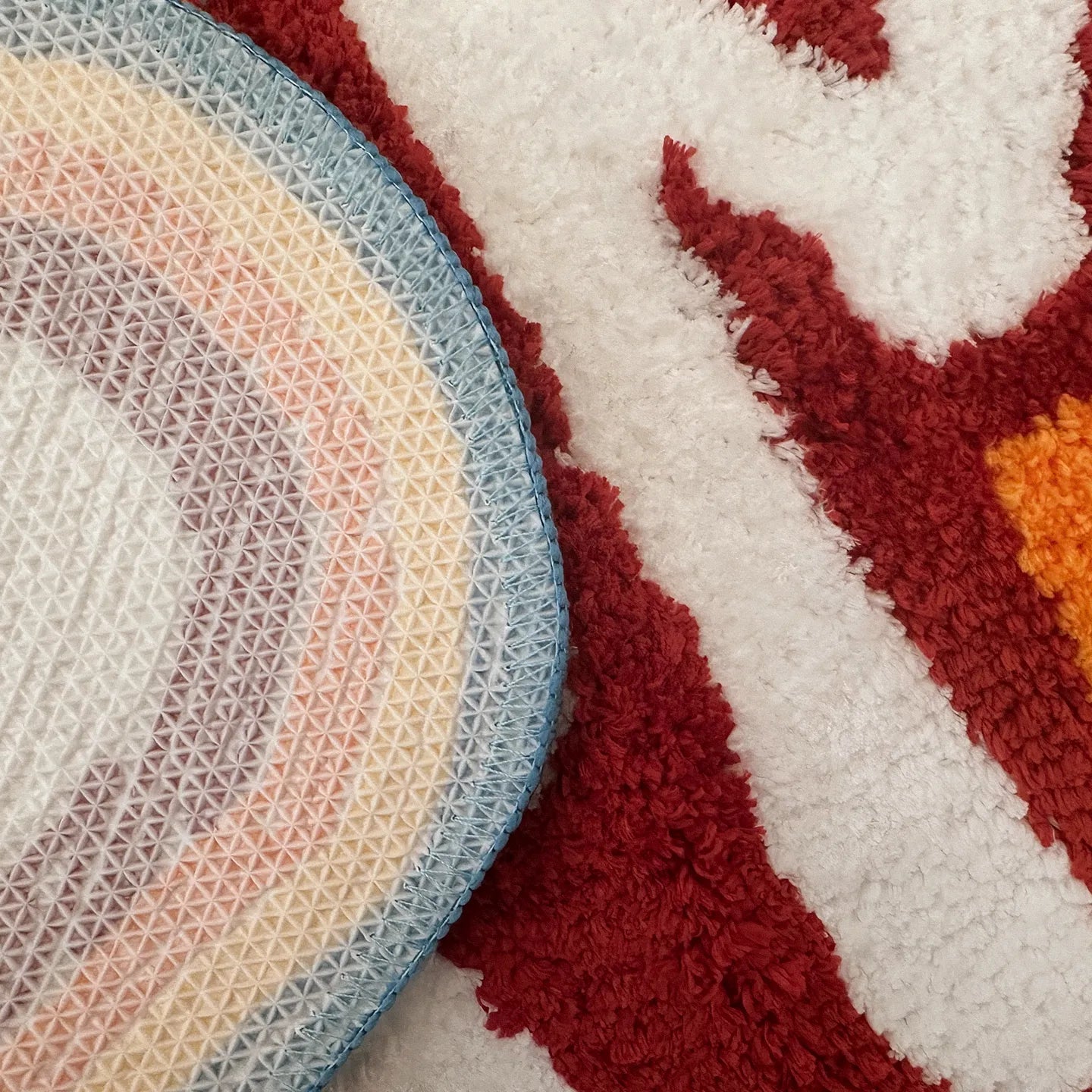 Close-up of a hand-tufted rainbow coloured runner rug by Housenfriends with the word 'DAMN', showing non-slip backing.