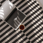 Open book and cup of tea on Stockholm Black and White Modern Offset Stripe Rug by Housenfriends