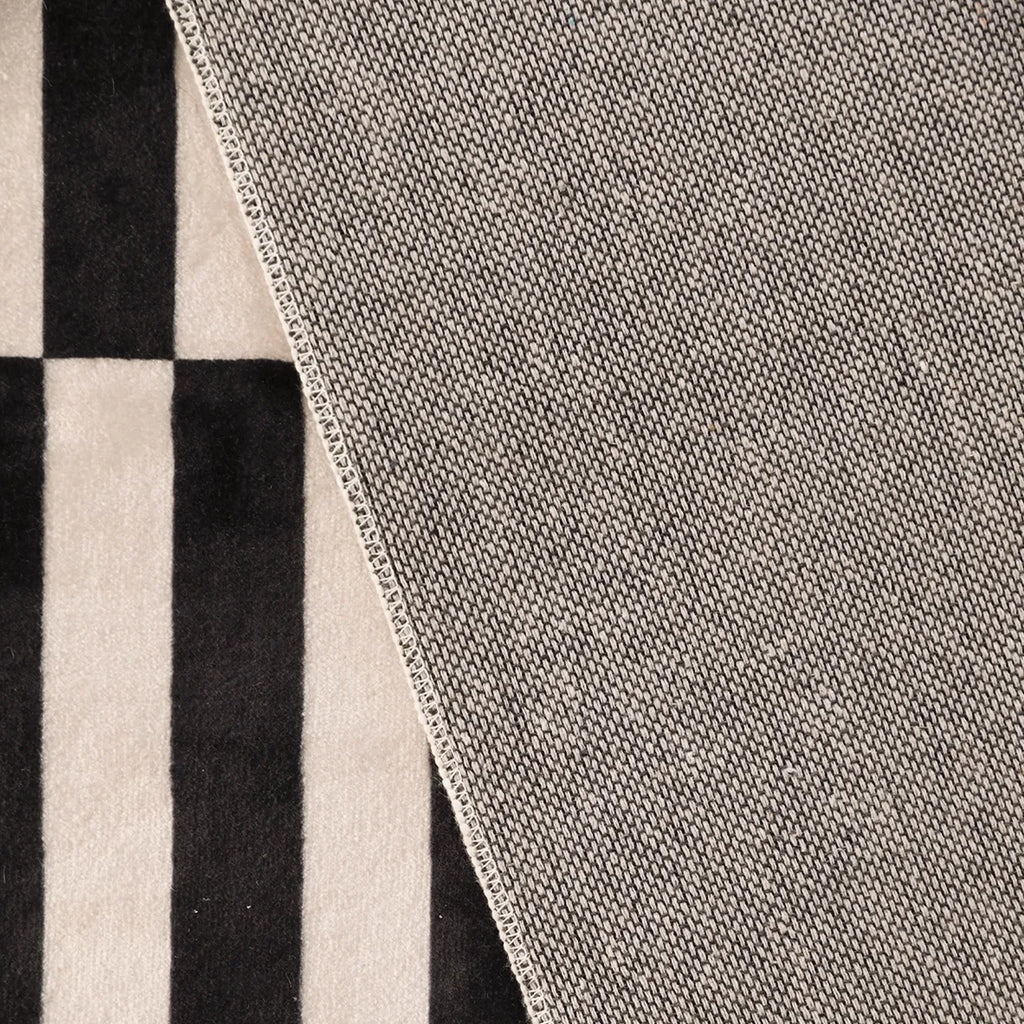 Close-up of the back of Stockholm Black and White Modern Offset Stripe Rug by Housenfriends