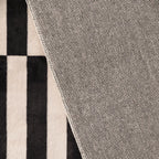 Close-up of the back of Stockholm Black and White Modern Offset Stripe Rug by Housenfriends