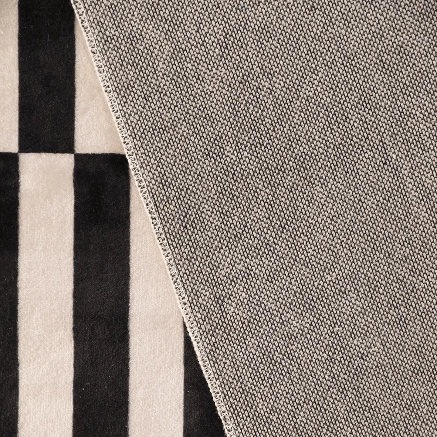 Close-up of the back of Stockholm Black and White Modern Offset Stripe Rug by Housenfriends