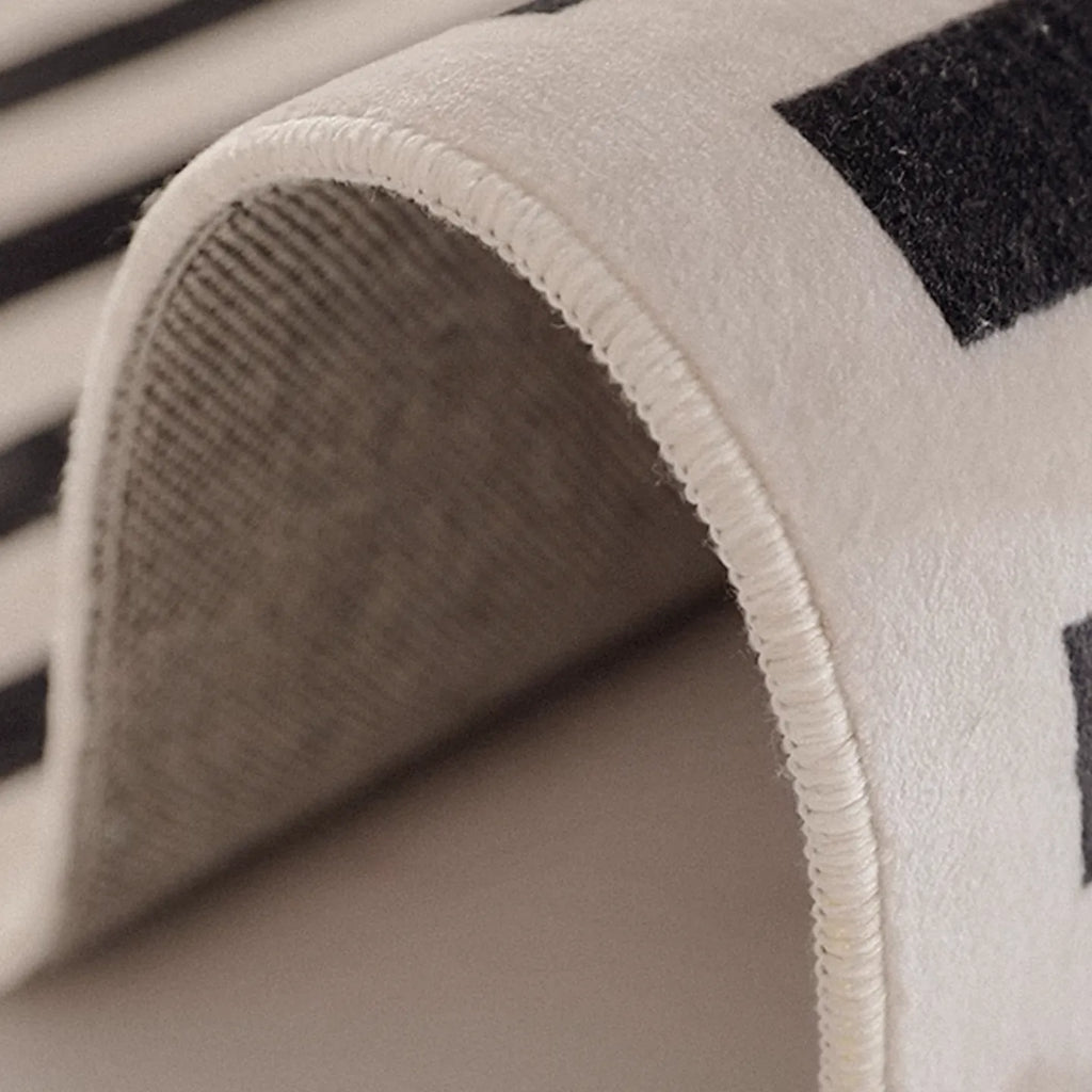 Close-up of a textured fabric of Stockholm Black and White Modern Offset Stripe Rug by Housenfriends