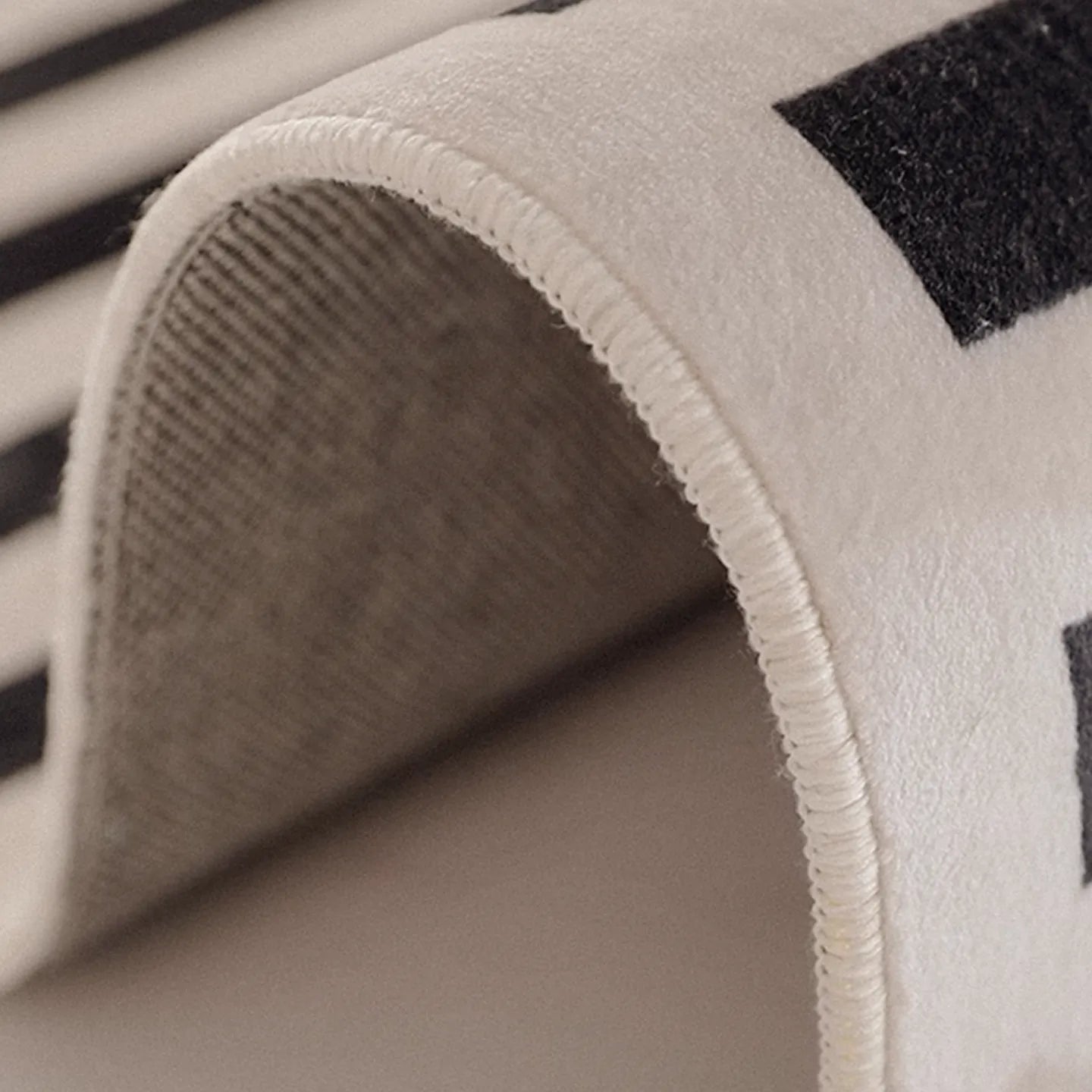 Close-up of a textured fabric of Stockholm Black and White Modern Offset Stripe Rug by Housenfriends