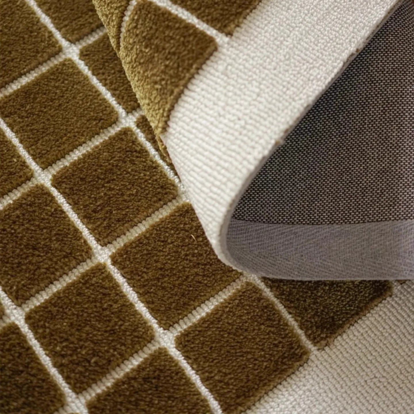 Close-up of a textured olive green rug with geometric pattern, Housenfriends