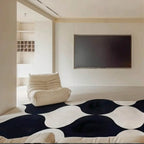 Modern living room with Nova black and white irregular wavy rug by Housenfriends with a white armchair and a flat-screen TV