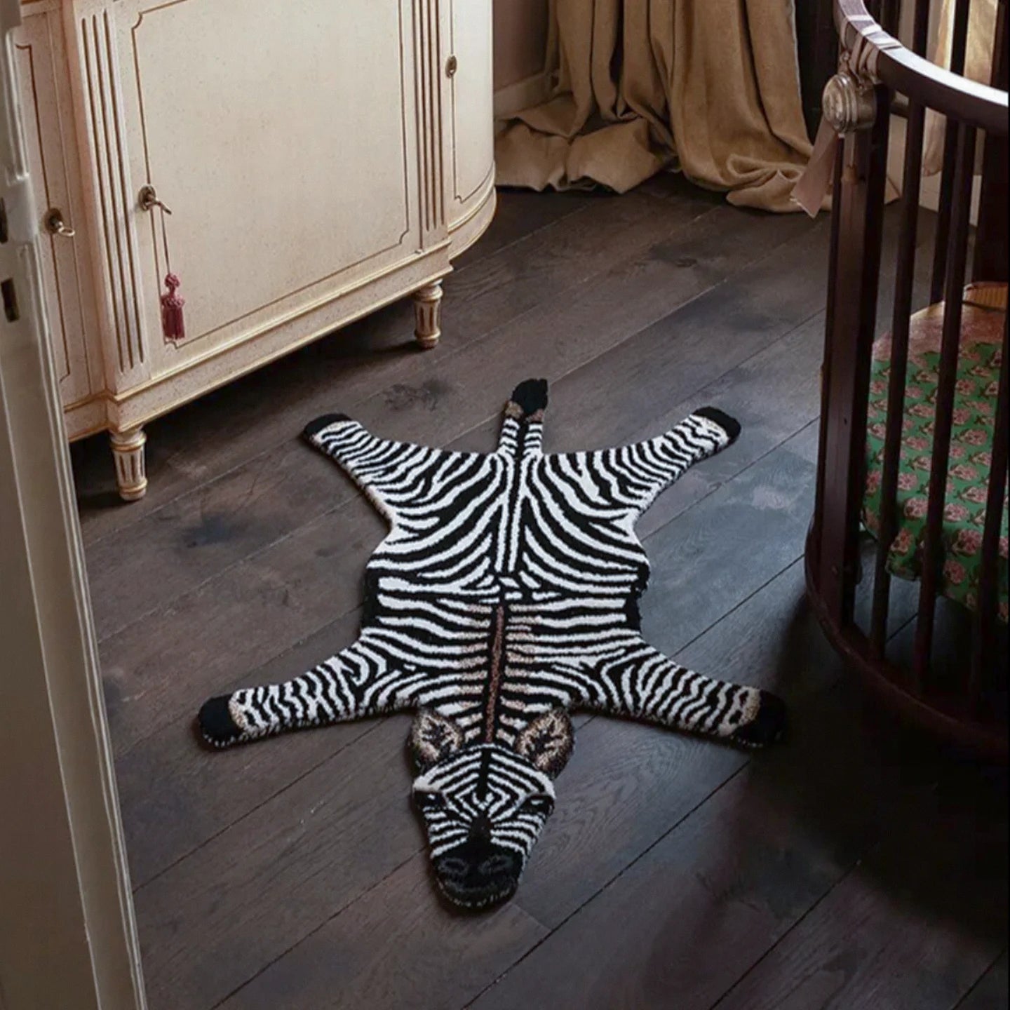 Zibi small zebra animal shaped rug in black and white by Housenfriends on a wooden floor in a room with furniture.