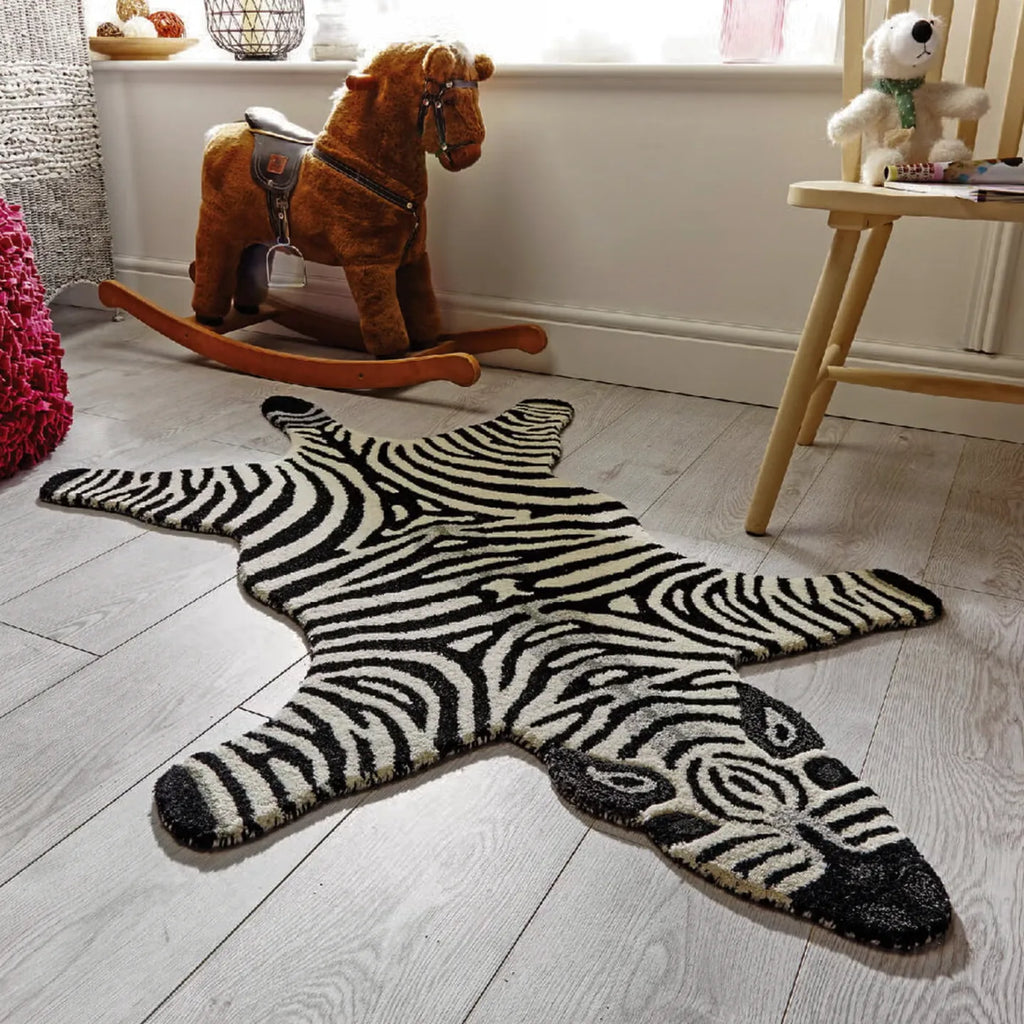 Zibi small zebra animal shaped rug in black and white by Housenfriends on a wooden floor with toys