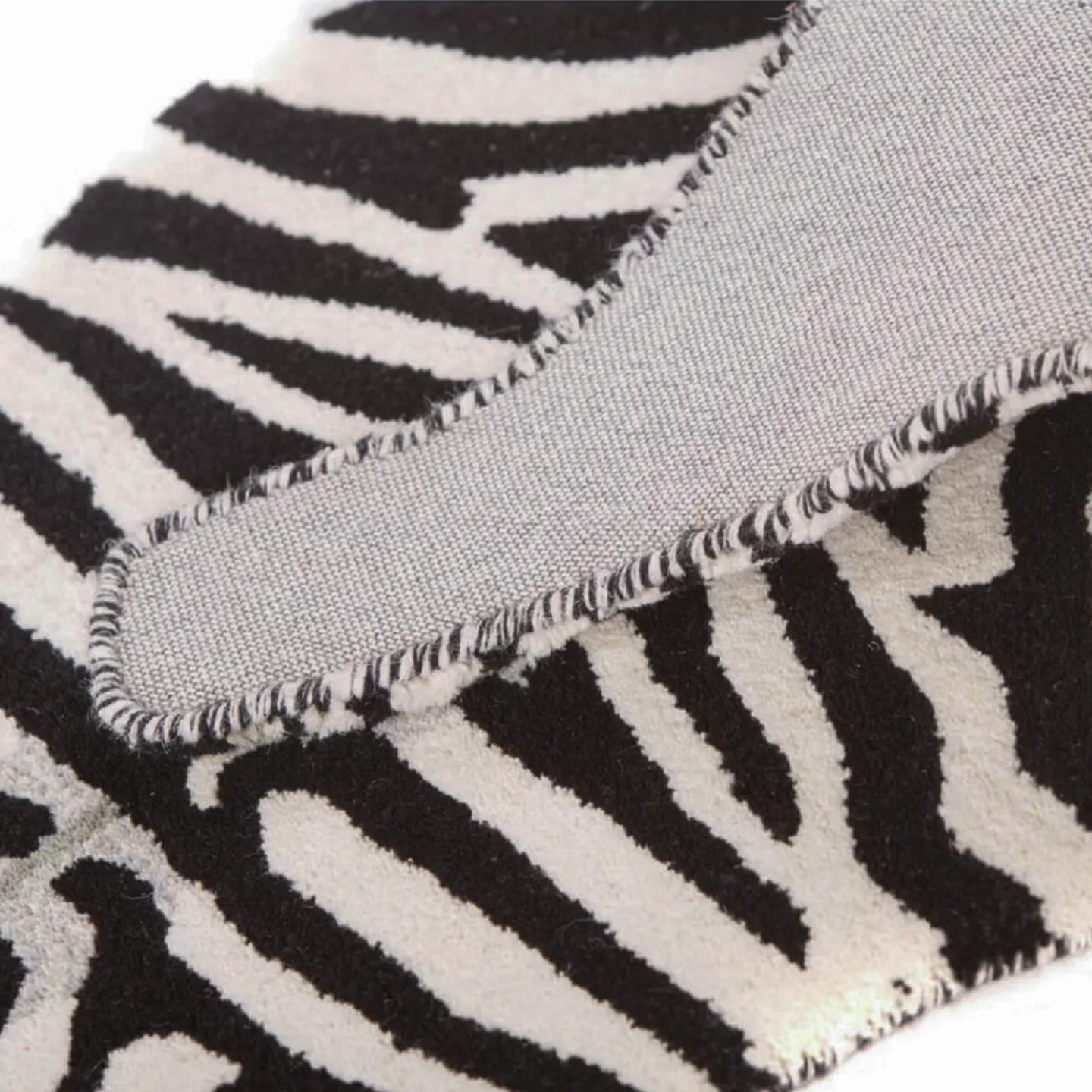 Close-up of black and white zebra-patterned rug by Housenfriends
