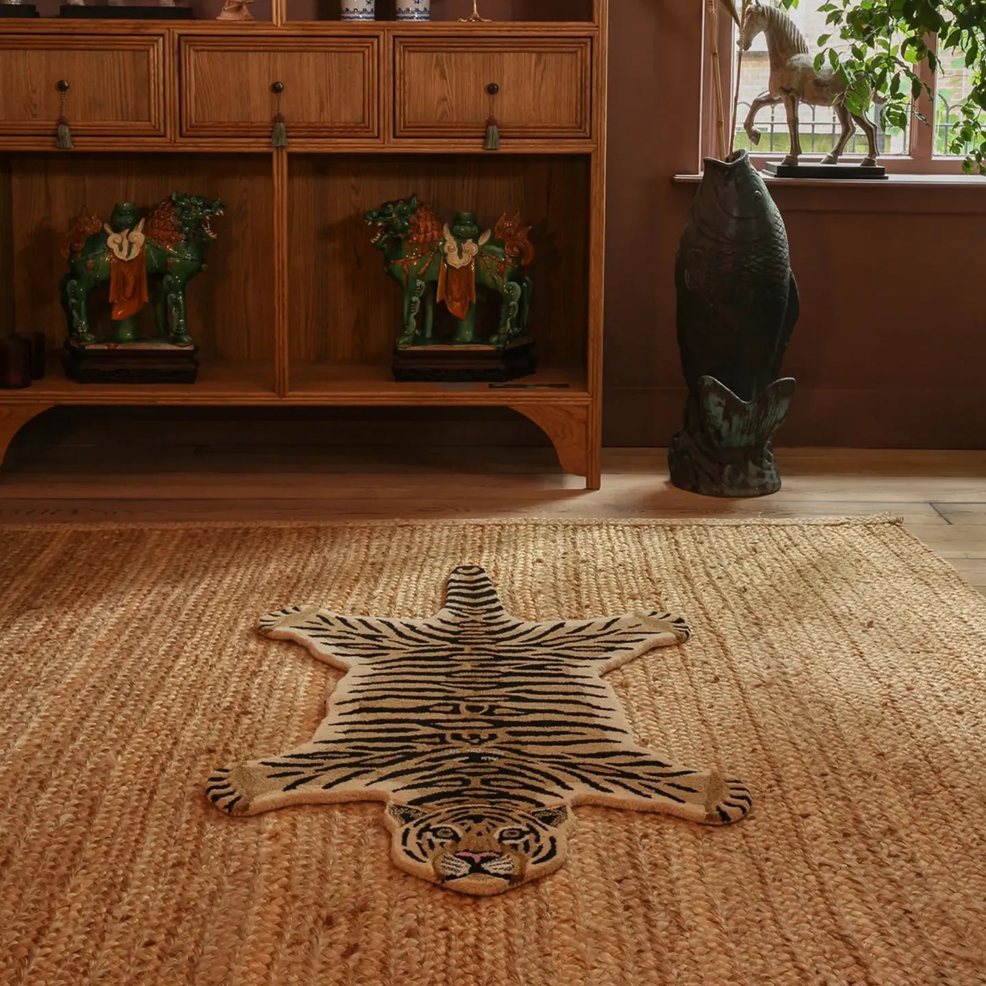 Tibi small tiger-shaped wool rug by Housenfriends on floor near wooden furniture and window