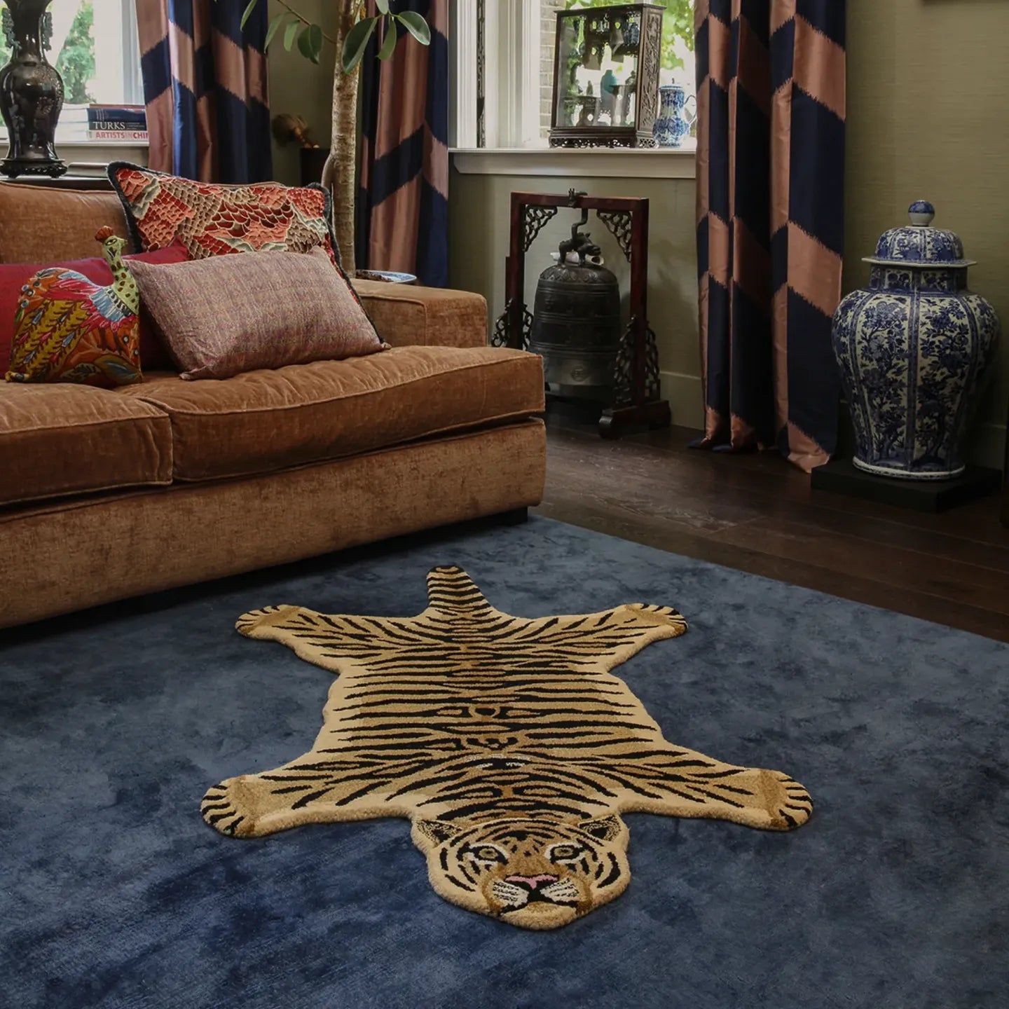 Living room with a Tibi small tiger-shaped wool rug by Housenfriends, brown sofa, and decorative items.