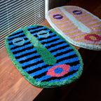 Milo pink and green small oval shaggy African mask rugs by Housenfriends next to window blinds