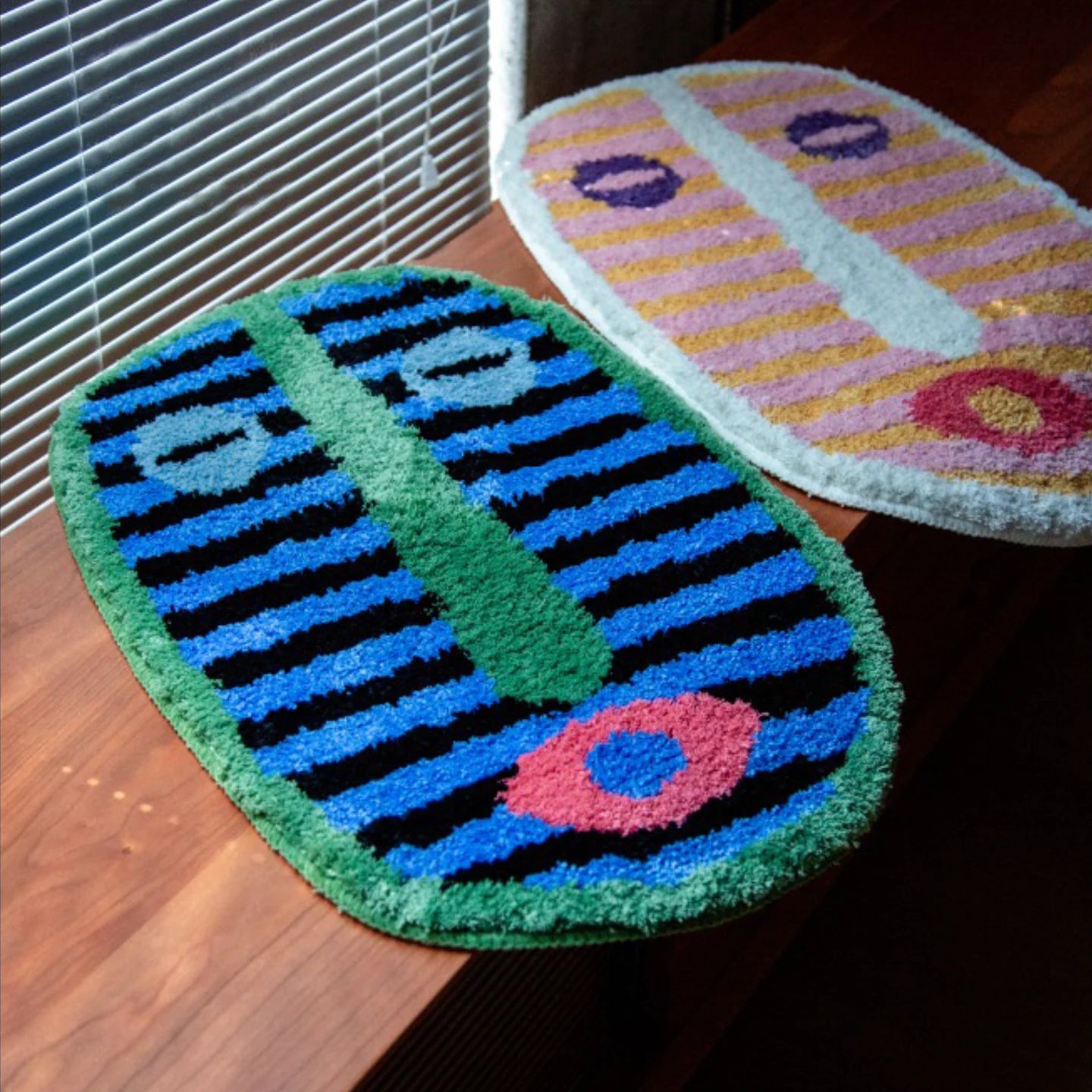 Milo pink and green small oval shaggy African mask rugs by Housenfriends next to window blinds