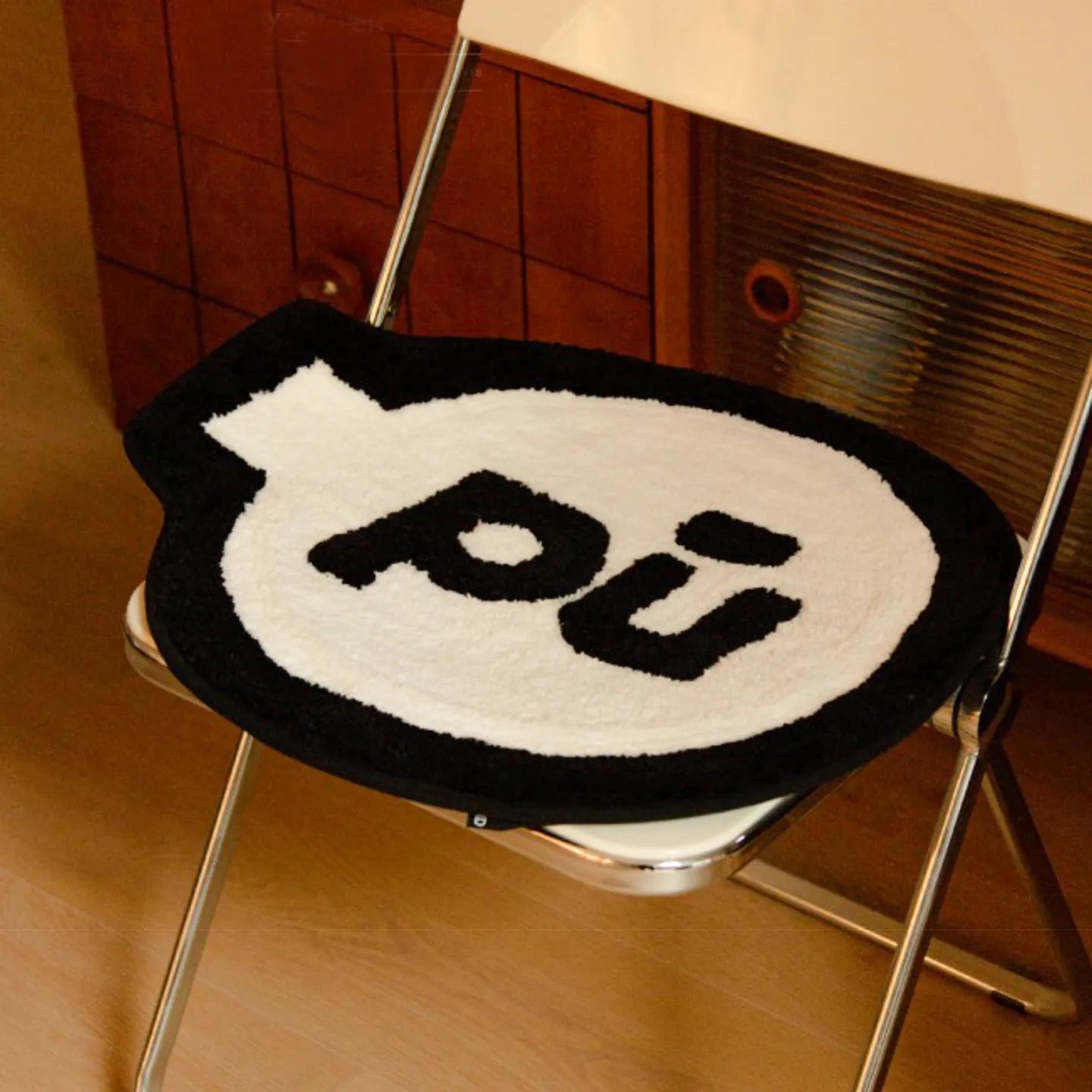 Pu white small shaggy rug with black outline by Housenfriends, grenade-like shape, on a white chair