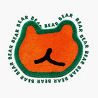Doki orange small shaggy bear-shaped rug with green outline by Housenfriends on white background