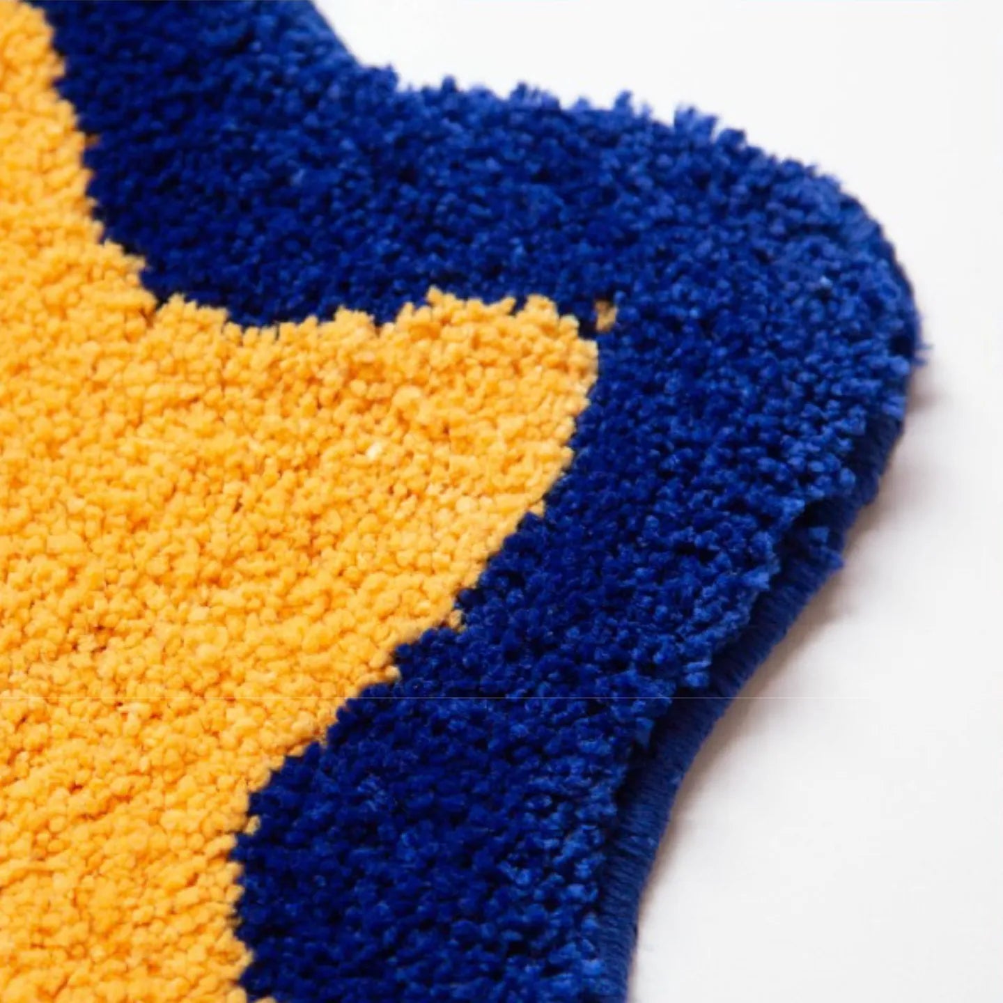 Close-up of hand-tufted Poki yellow cat-shaped rug with blue outline by Housenfriends