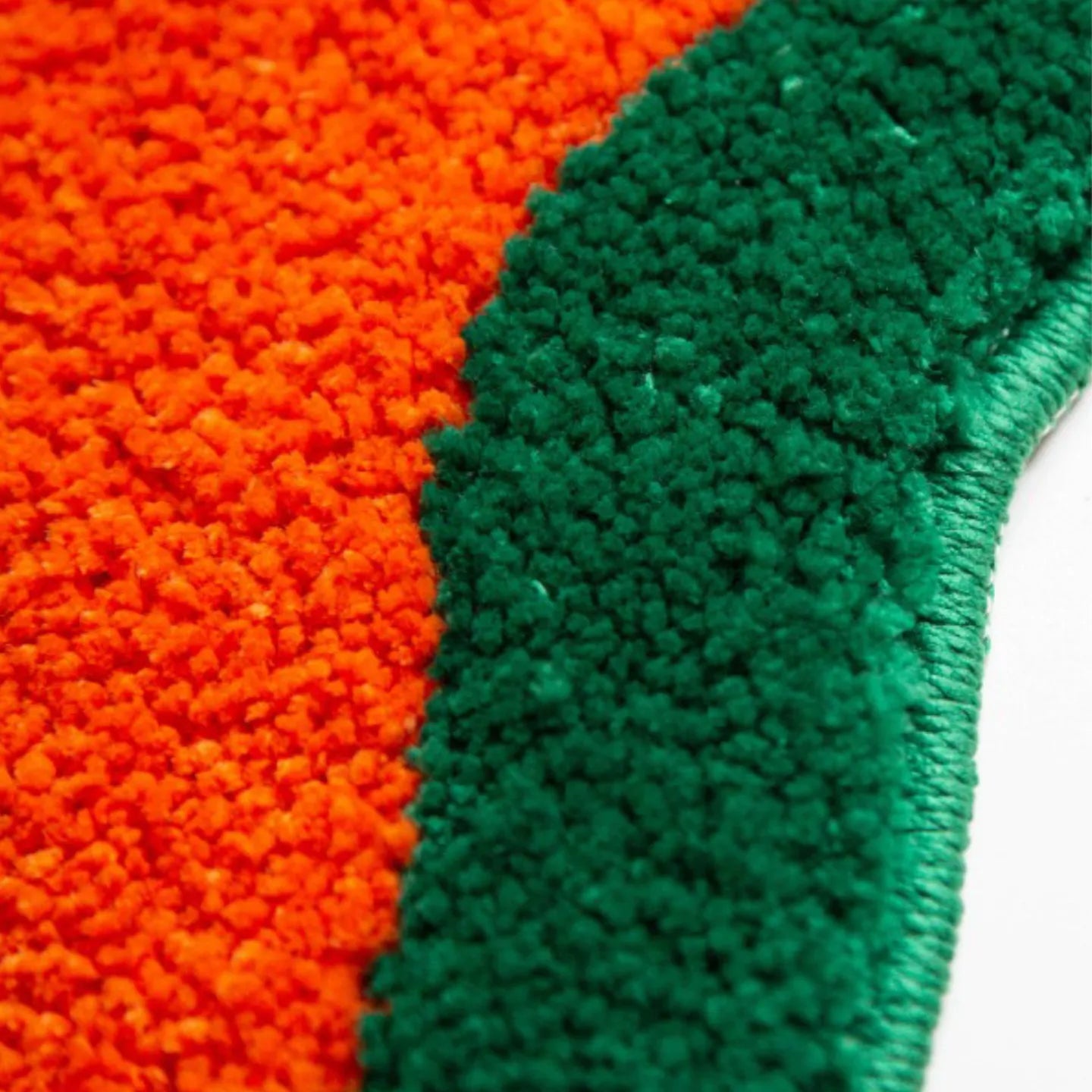 Close-up of orange and green textured fabric of Housenfriends rug