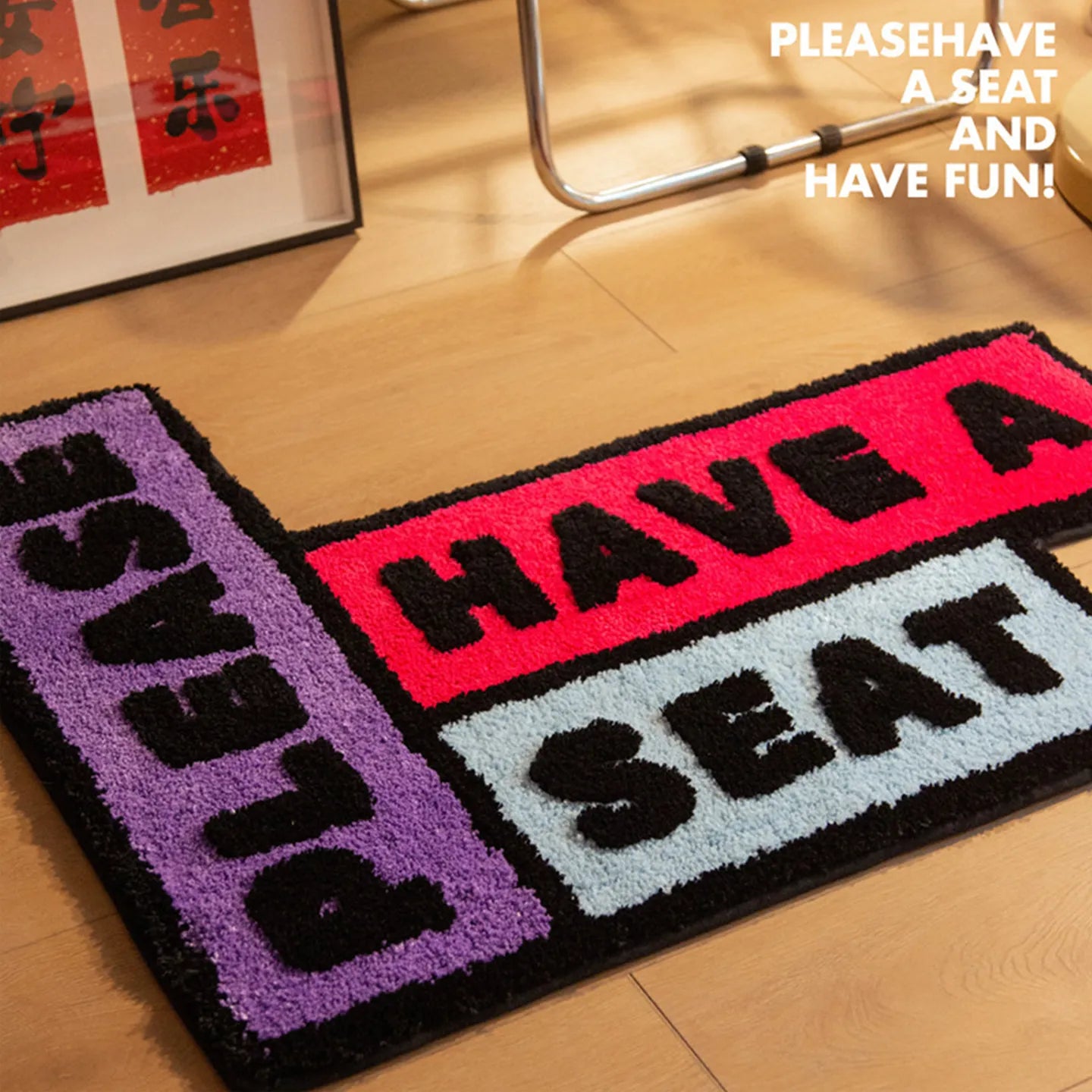 'Please Have a Seat' graphic word art rug in purple, black, pink and blue by Housenfriends on a wooden floor.