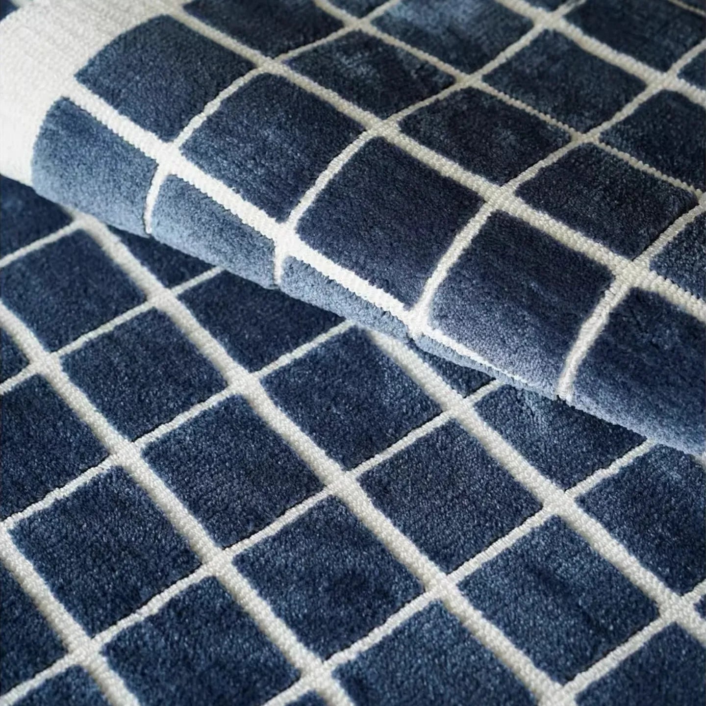 Close-up of the Salina navy blue checkered modern rug by Housenfriends, showing its soft texture.