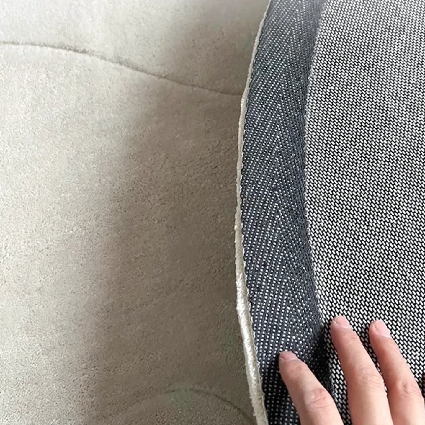 Close-up of the non-slip backing of the Cora off-white irregular wavy rug by Housenfriends