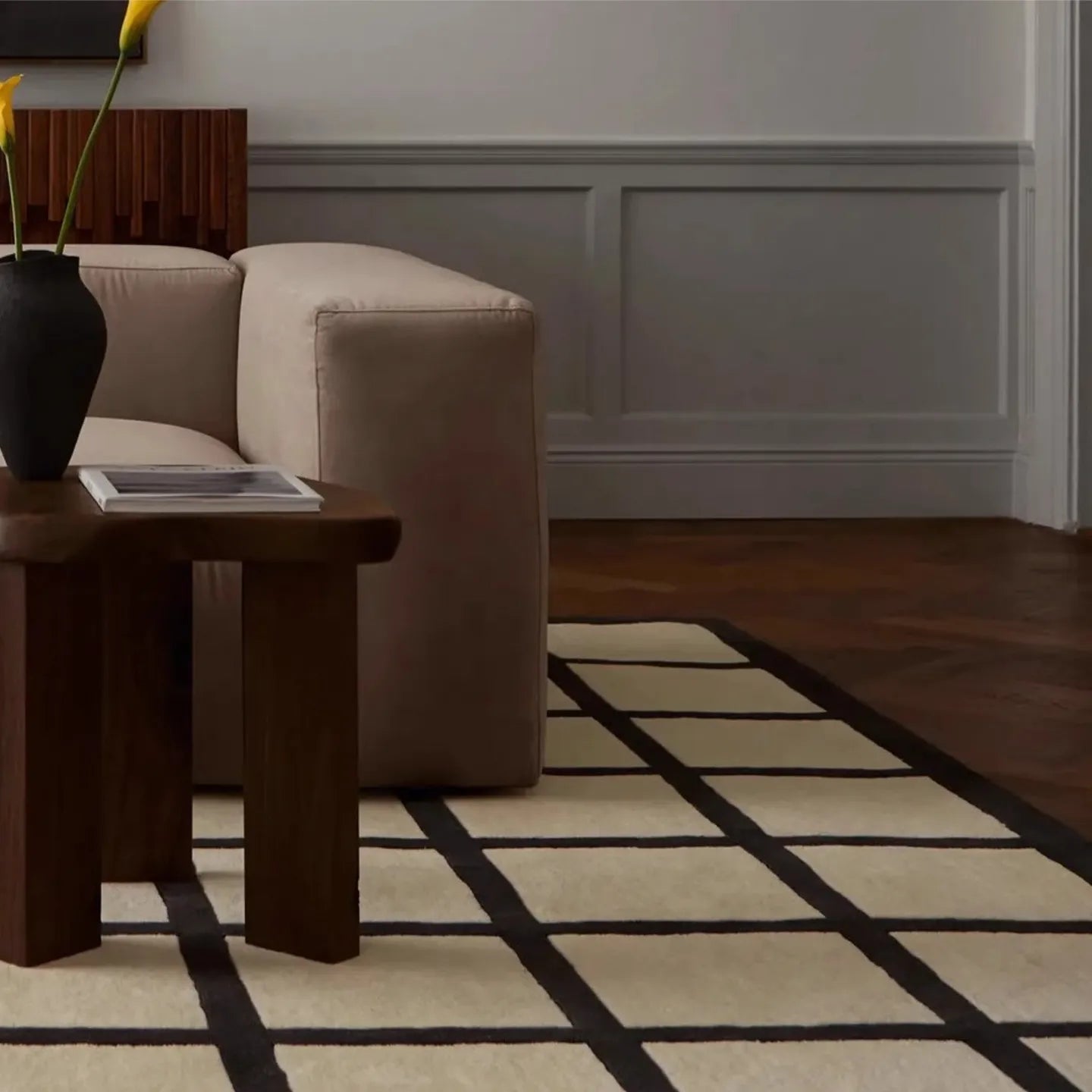 Living room with a beige sofa, wooden side table, and Studio Black and Cream Checkered Cut Pile Rug by Housenfriends