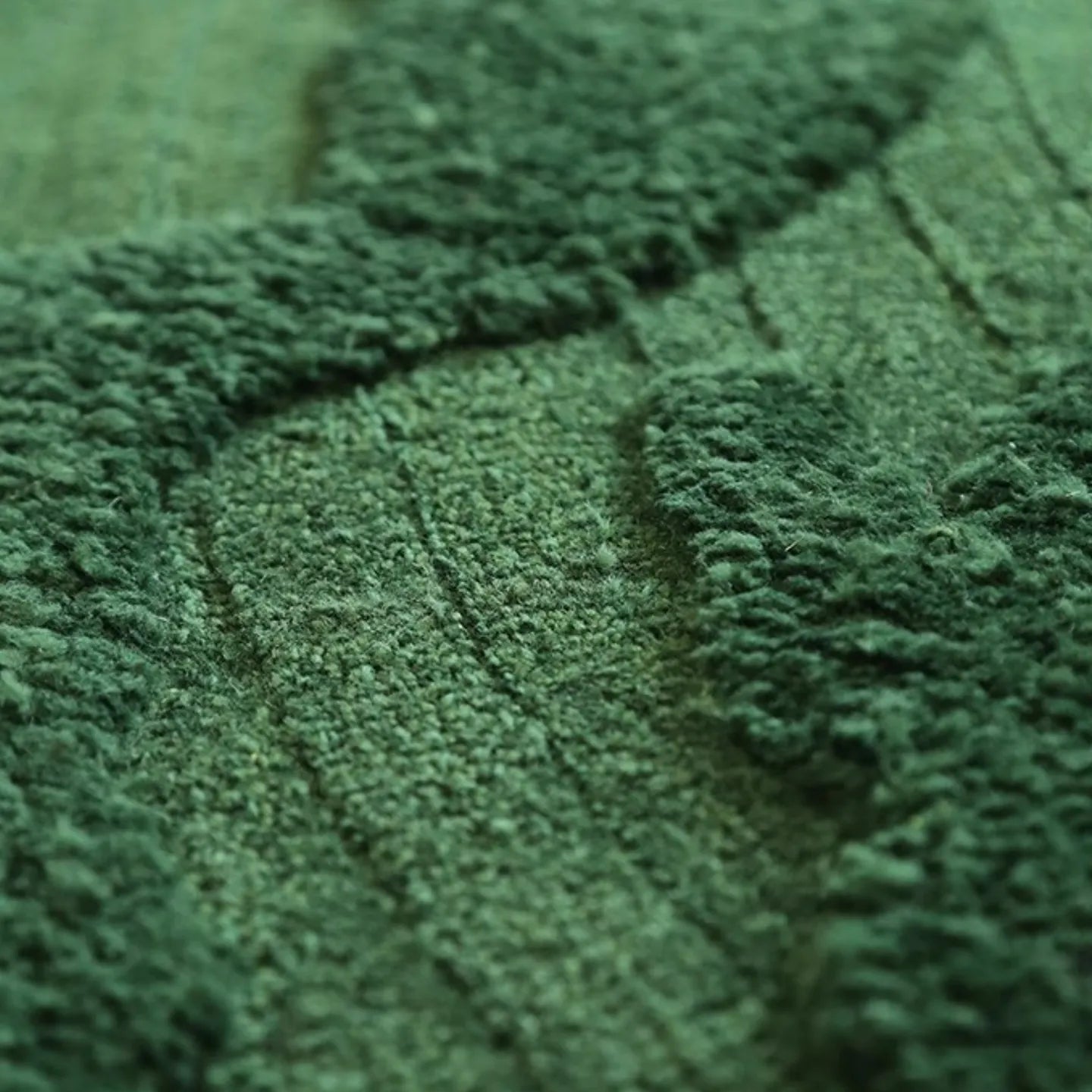 Close-up of textured high low pile fabric of Verdure Deep Green moss-inspired rug from Housenfriends