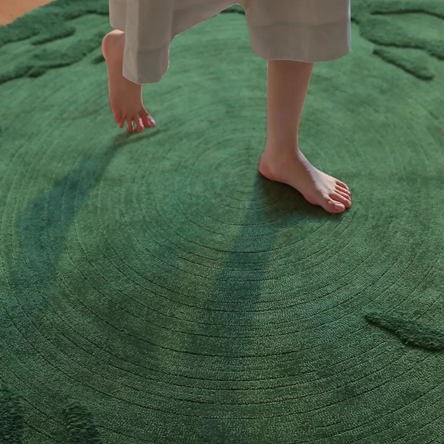 Person walking on Verdure Deep Green moss-inspired high low pile rug from Housenfriends