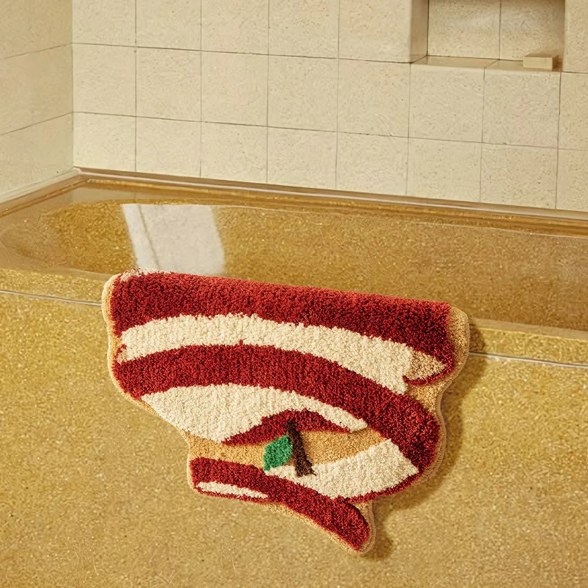 Gala Peeled Red and White Apple Shaped Tufted Rug by Housenfriends on a tiled bathroom floor.