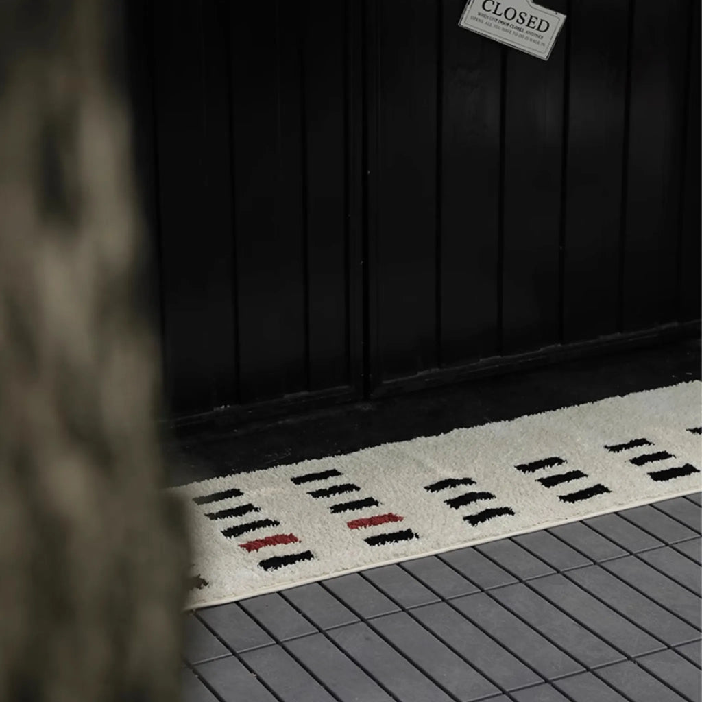 Arlo White and Black Checkered Tufted Runner by Housenfriends in front of a closed door