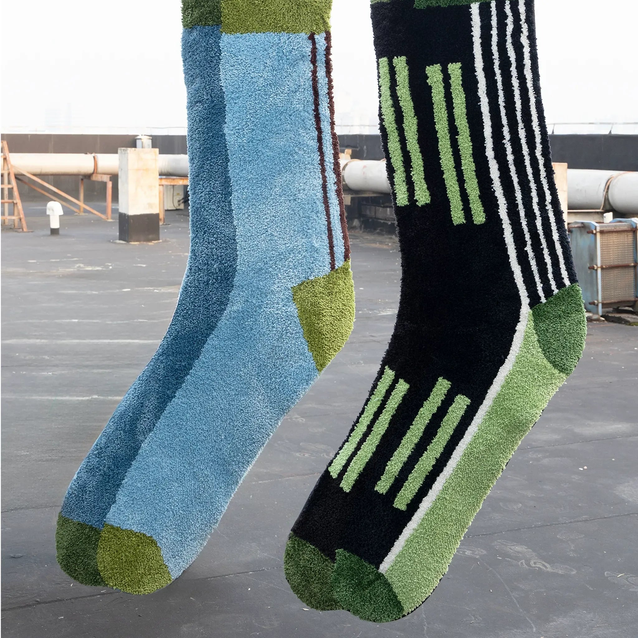 Blue and green colourblock sock shaped rug and black graphic striped sock rug hanging together by Housenfriends