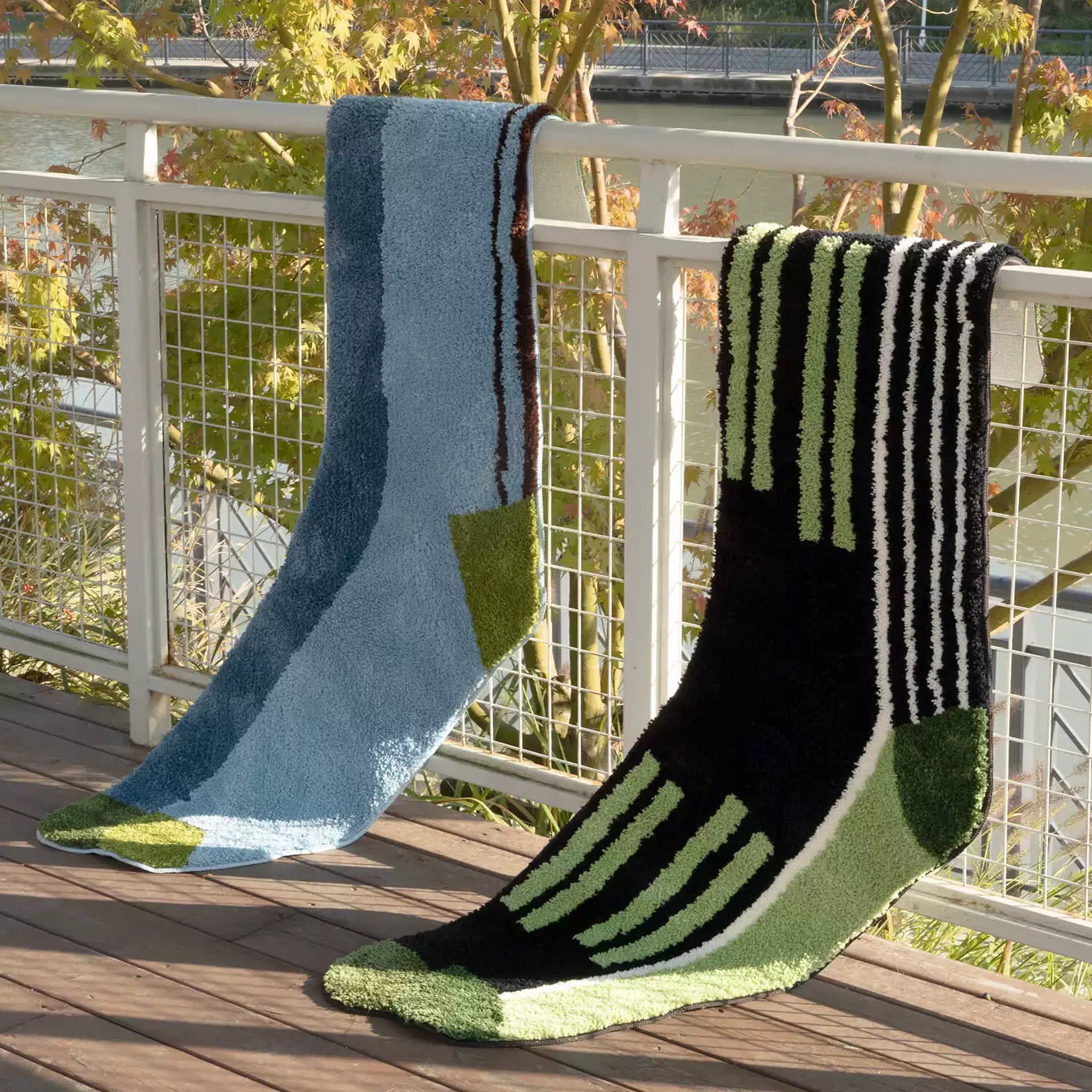 Blue and green graphic colourblock sock shaped rug with black and green striped sock rug styled on a balcony by Housenfriends