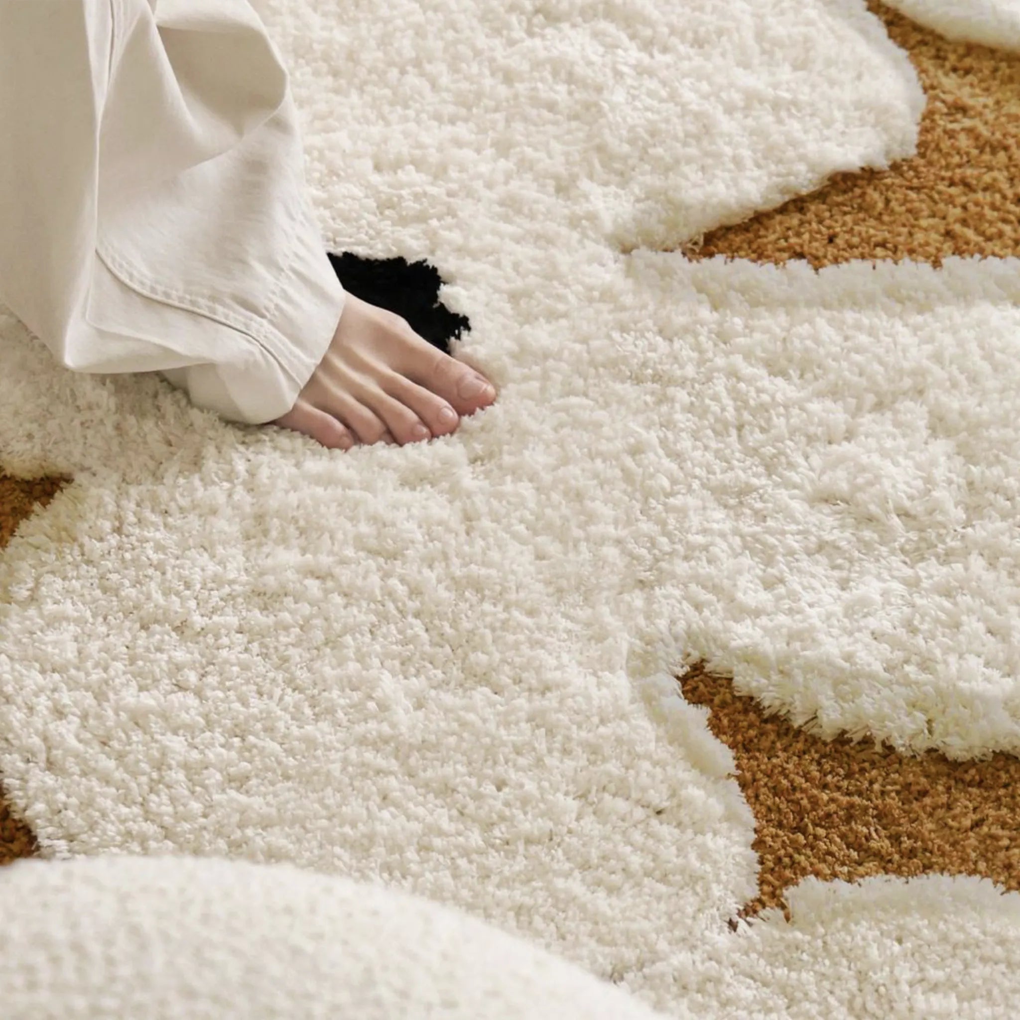 Close-up of a foot stepping onto the Liora Brown Ivory Floral Round Tufted High Low Rug by Housenfriends