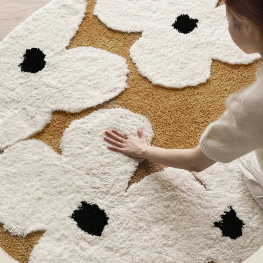 Person touching the Liora Brown Ivory Floral Round Tufted High Low Rug by Housenfriends