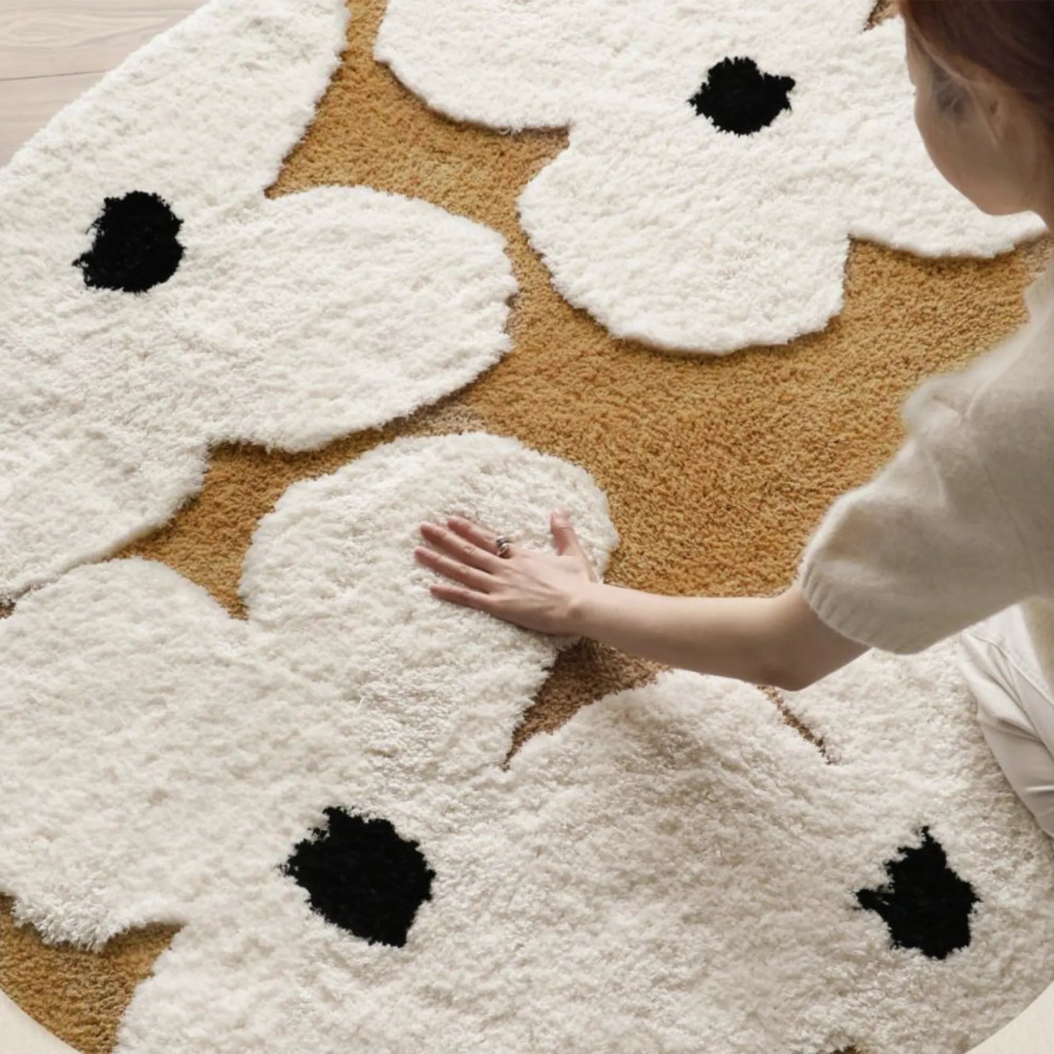 Person touching the Liora Brown Ivory Floral Round Tufted High Low Rug by Housenfriends