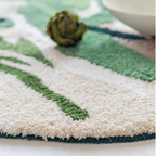 Cassia Forest Green Monstera Leaf Irregular Tufted Rug, edge and binding detail with cream and green sections